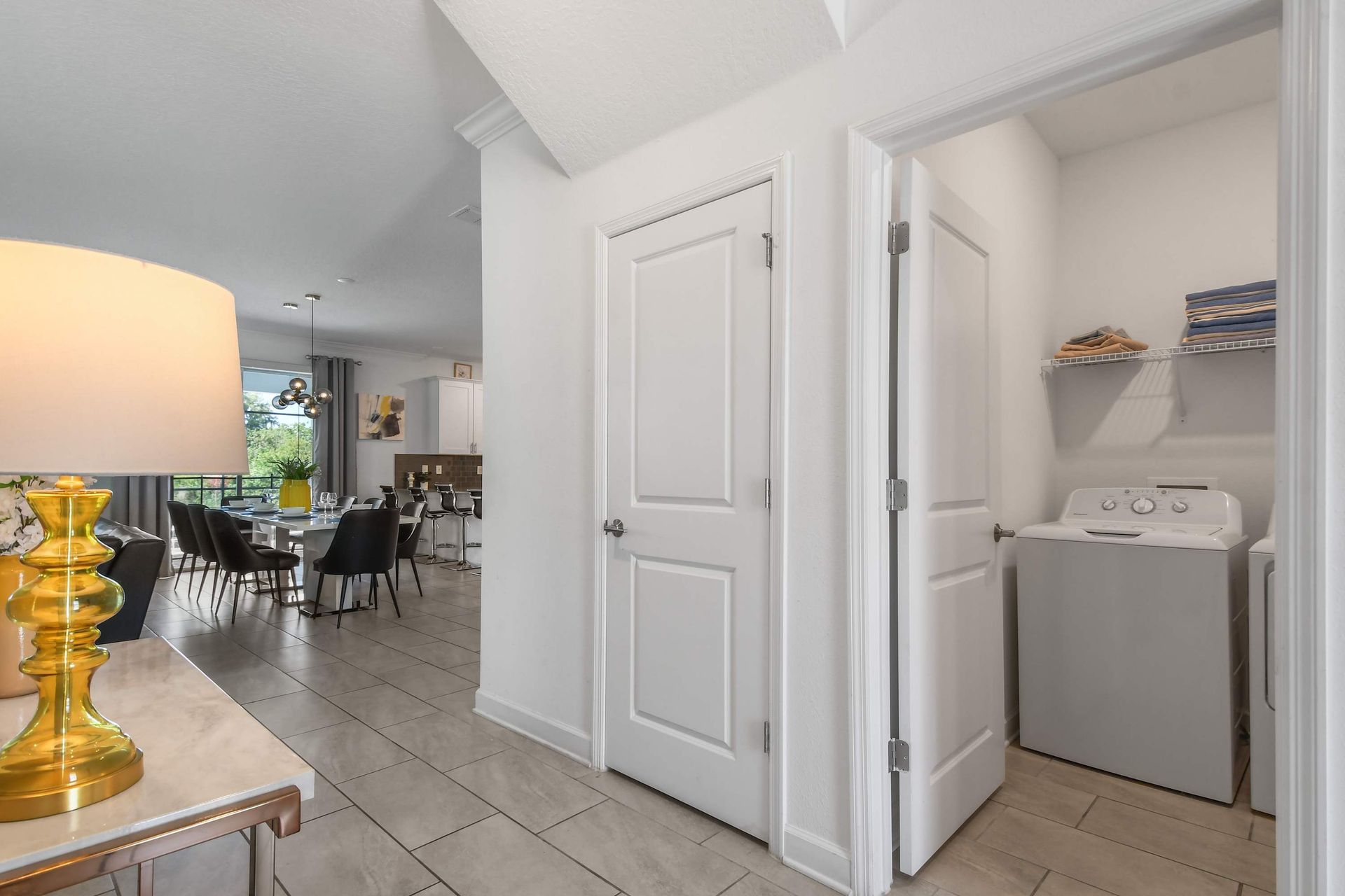 Convenient in-home laundry room with washer, dryer, and storage shelves for essentials