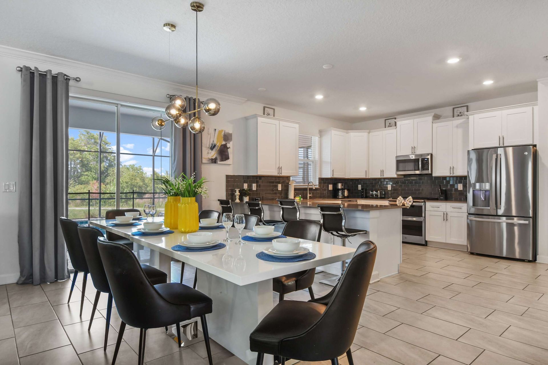 Modern kitchen with sleek appliances, white cabinetry, and a spacious island with seating.