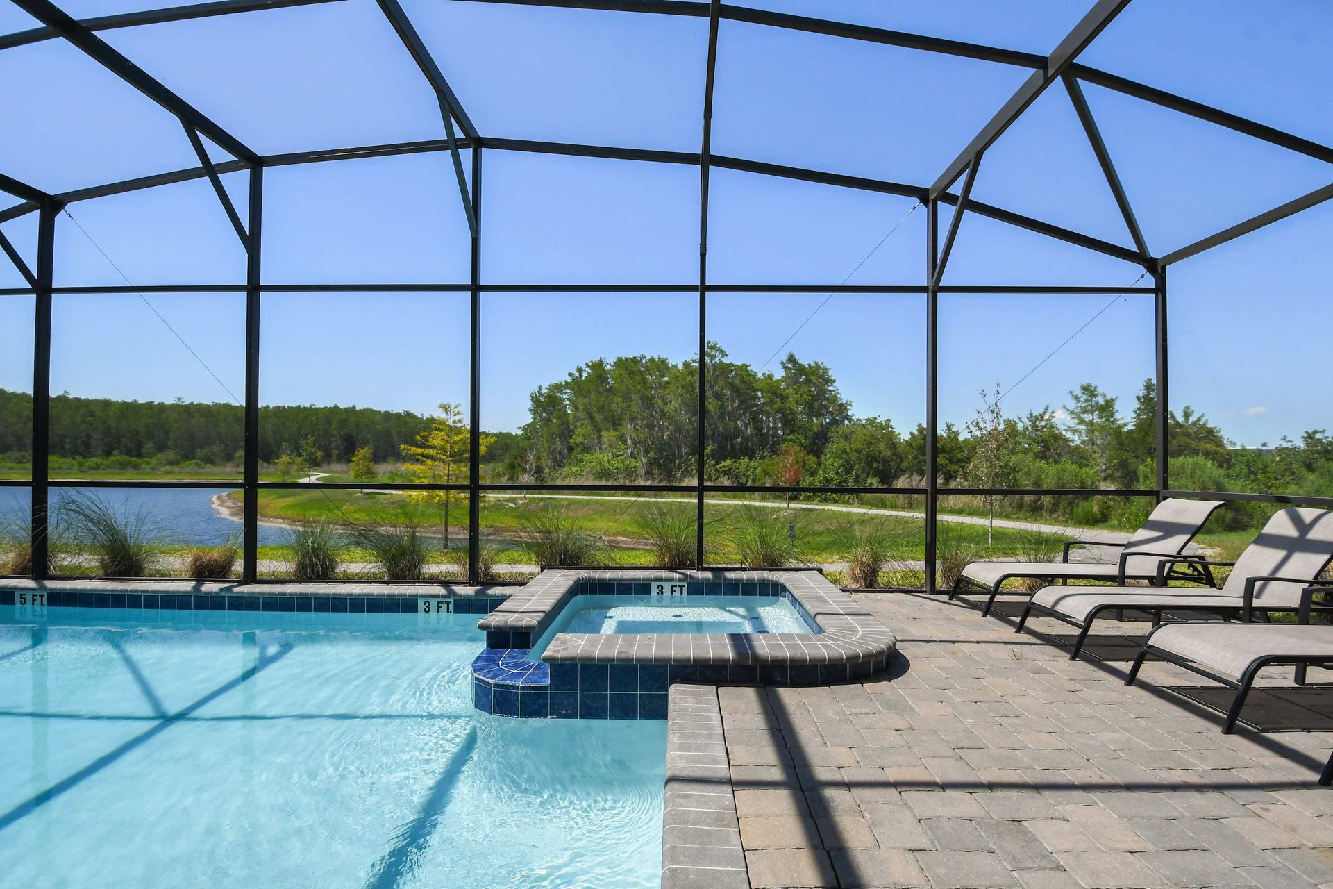 Private screened-in pool and spa with stunning lake views and cozy lounge chairs