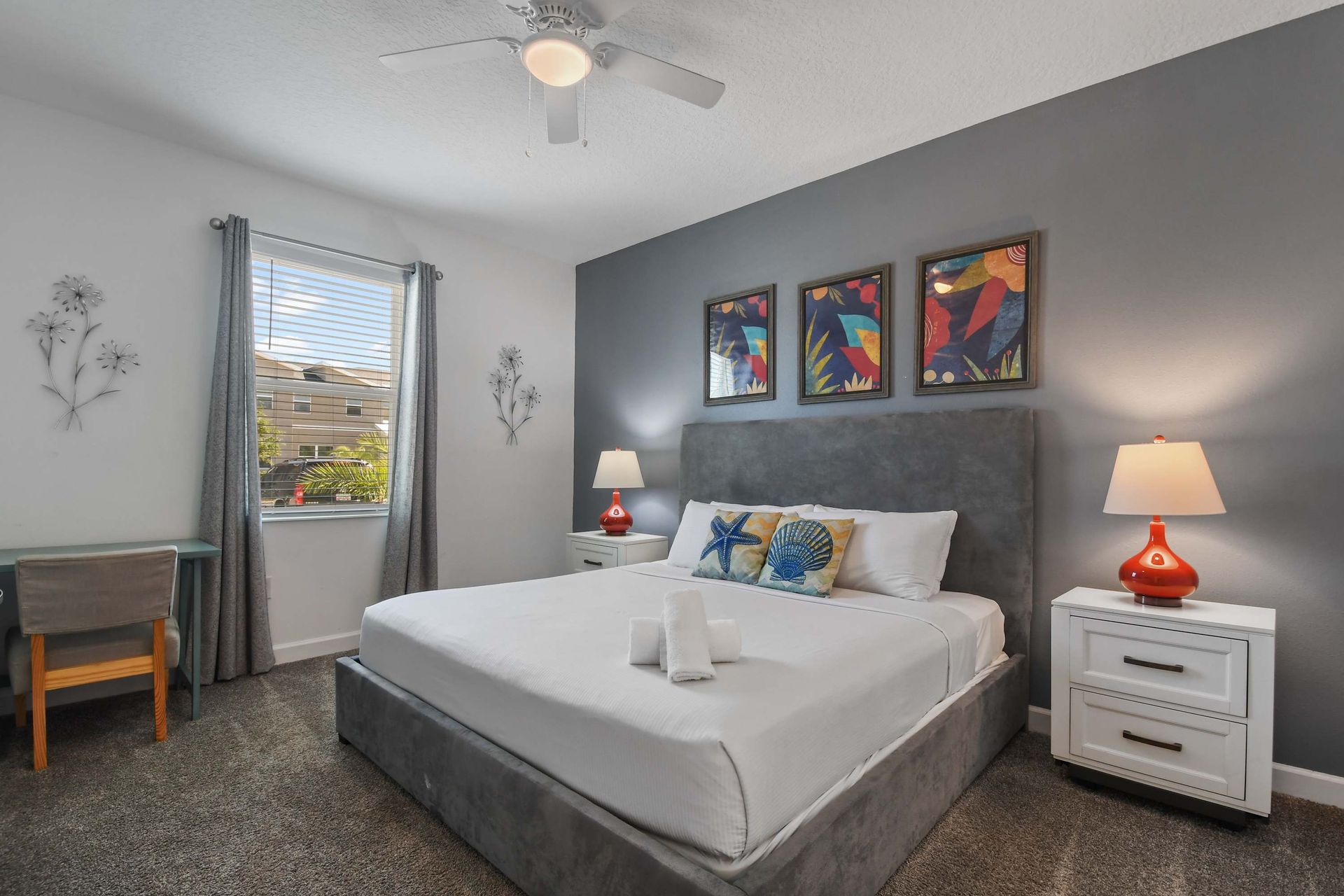 Chic and cozy bedroom with a plush bed, vibrant decor, and a relaxing workspace