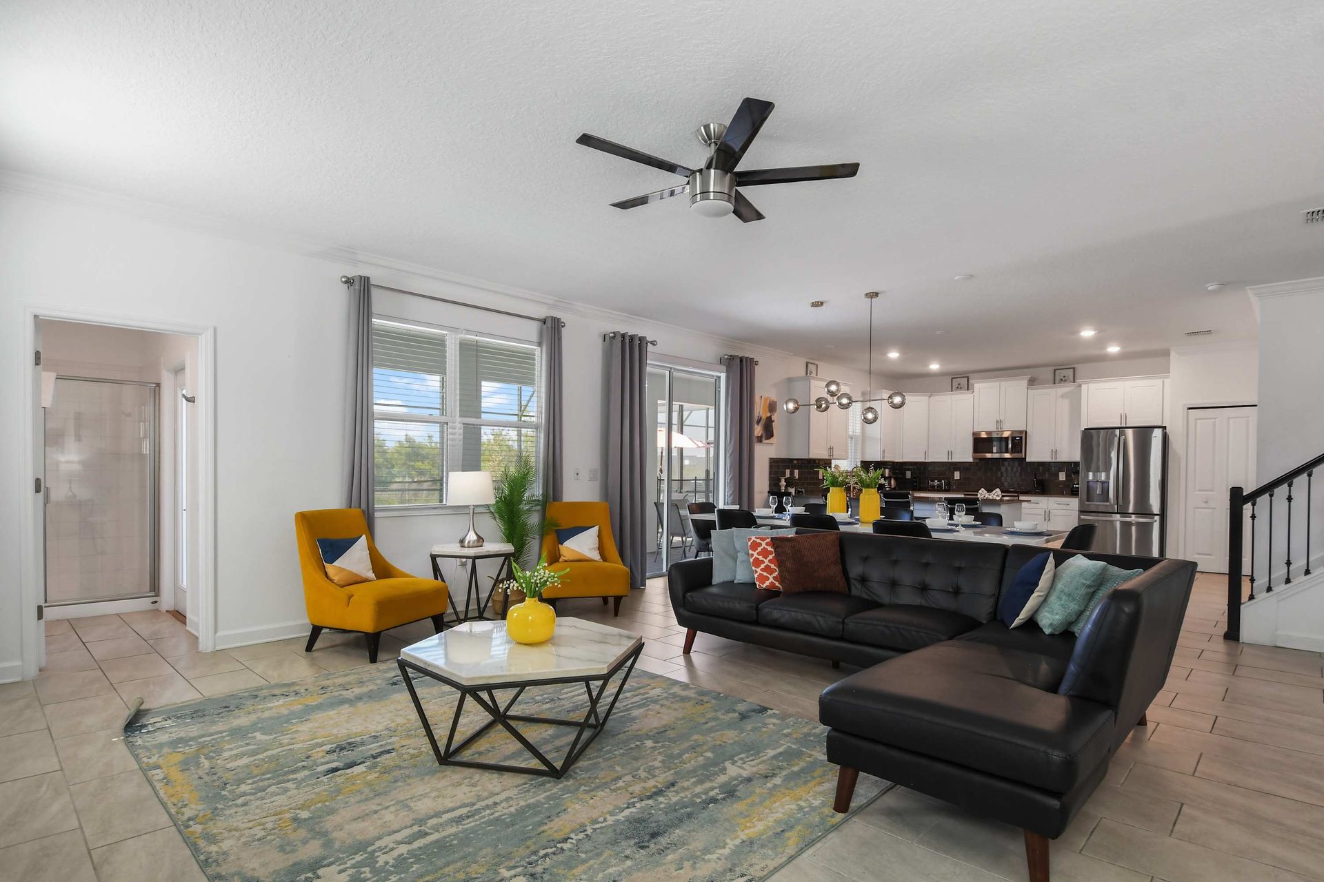 Spacious open-concept living area with modern decor, cozy seating, and a full kitchen.