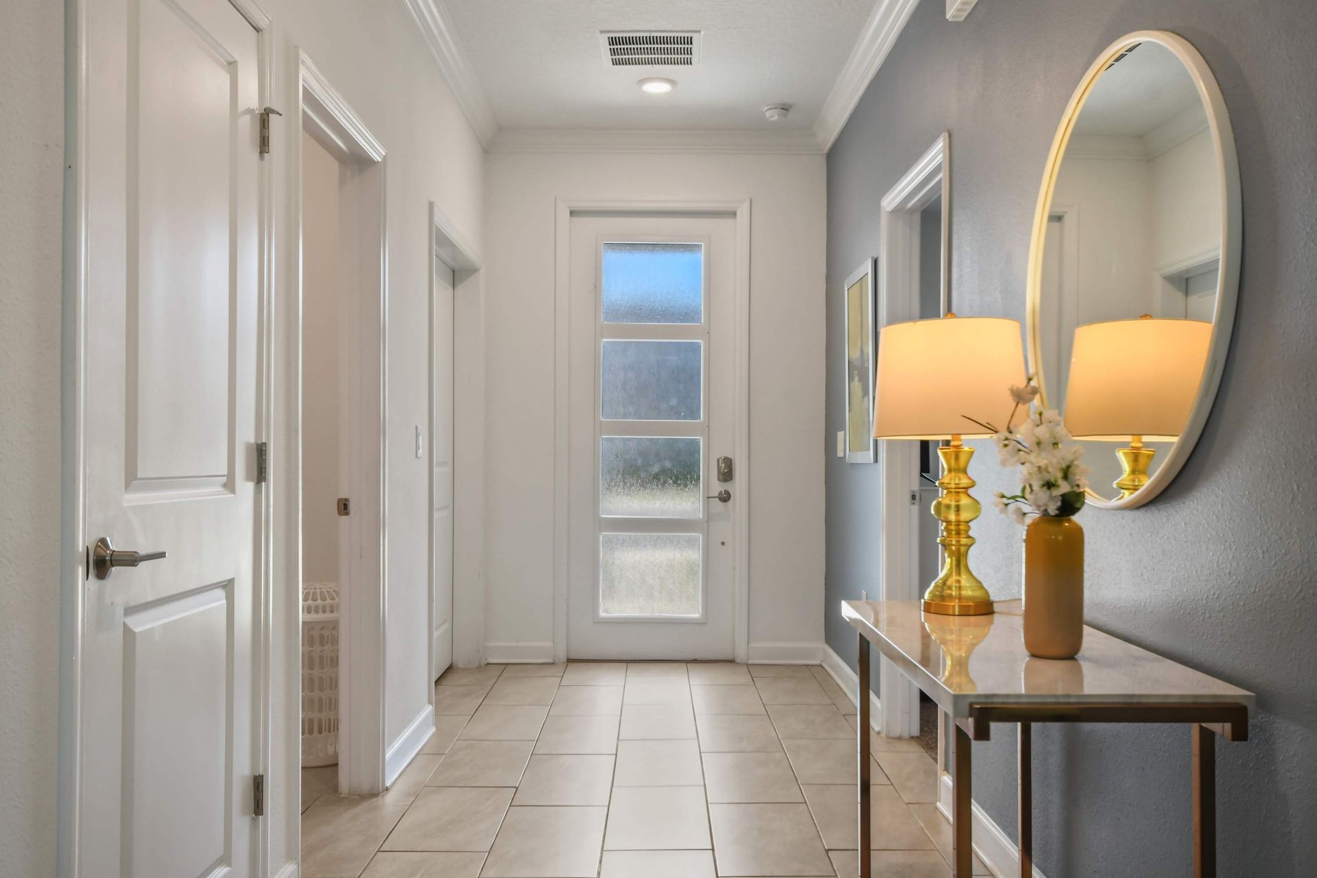Elegant entryway with modern decor, warm lighting, and a stylish gold-accented table