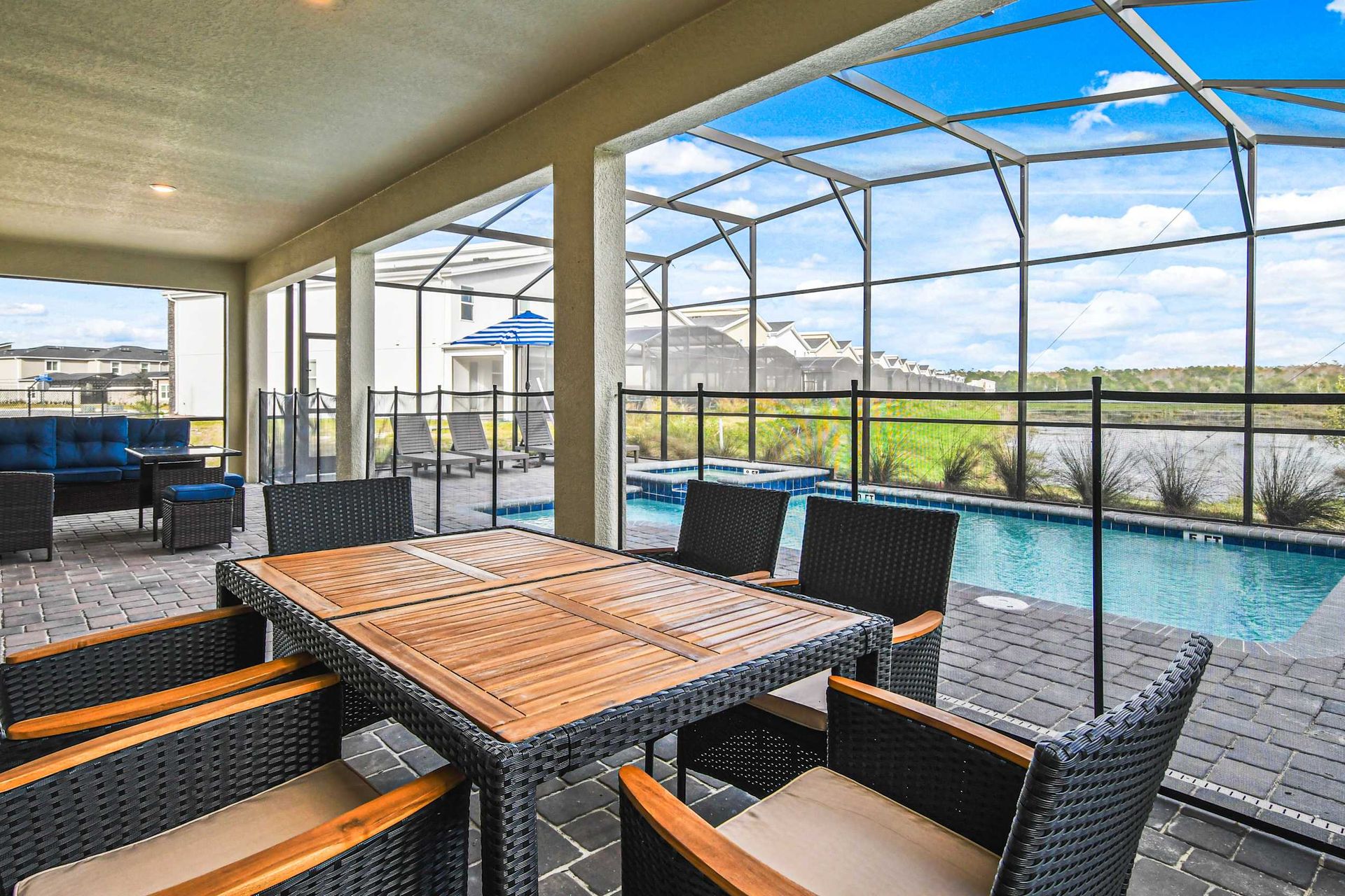 Spacious screened-in patio with dining, lounge seating, and a private pool with views.