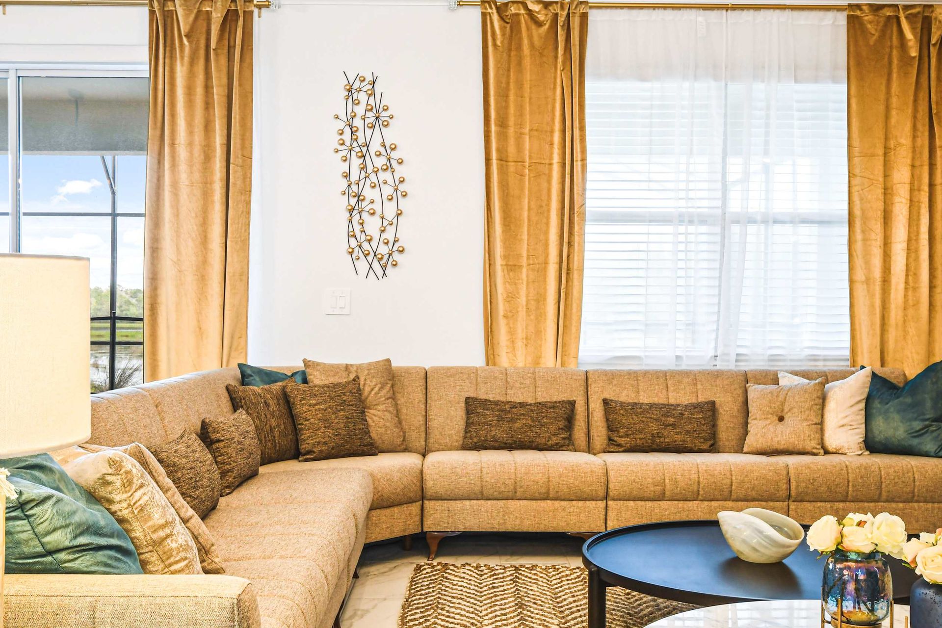 Elegant living room with a cozy sectional, gold accents, and stylish decor.