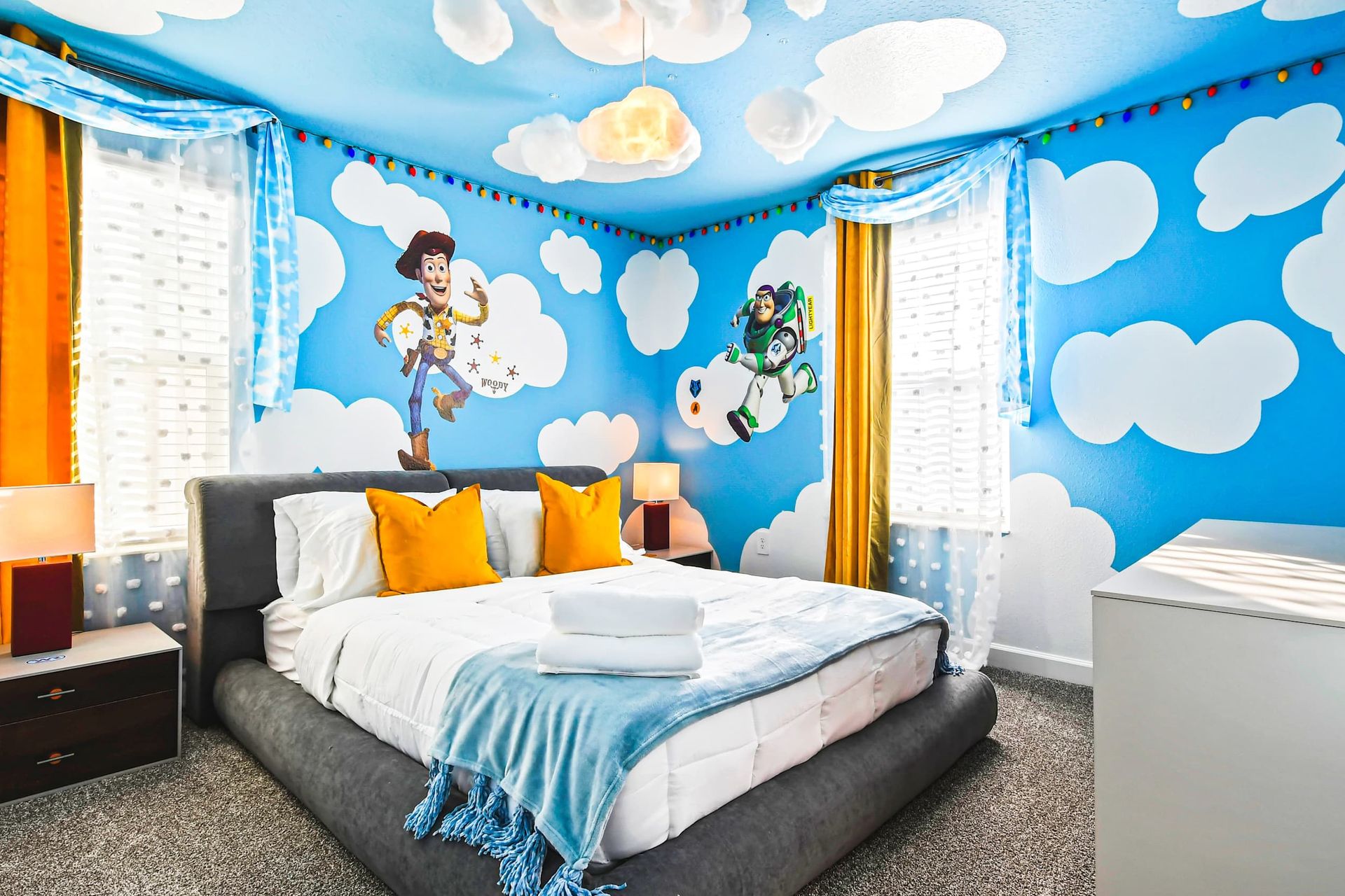 Whimsical Toy Story-themed bedroom with cloud murals, playful decor, and cozy bedding.