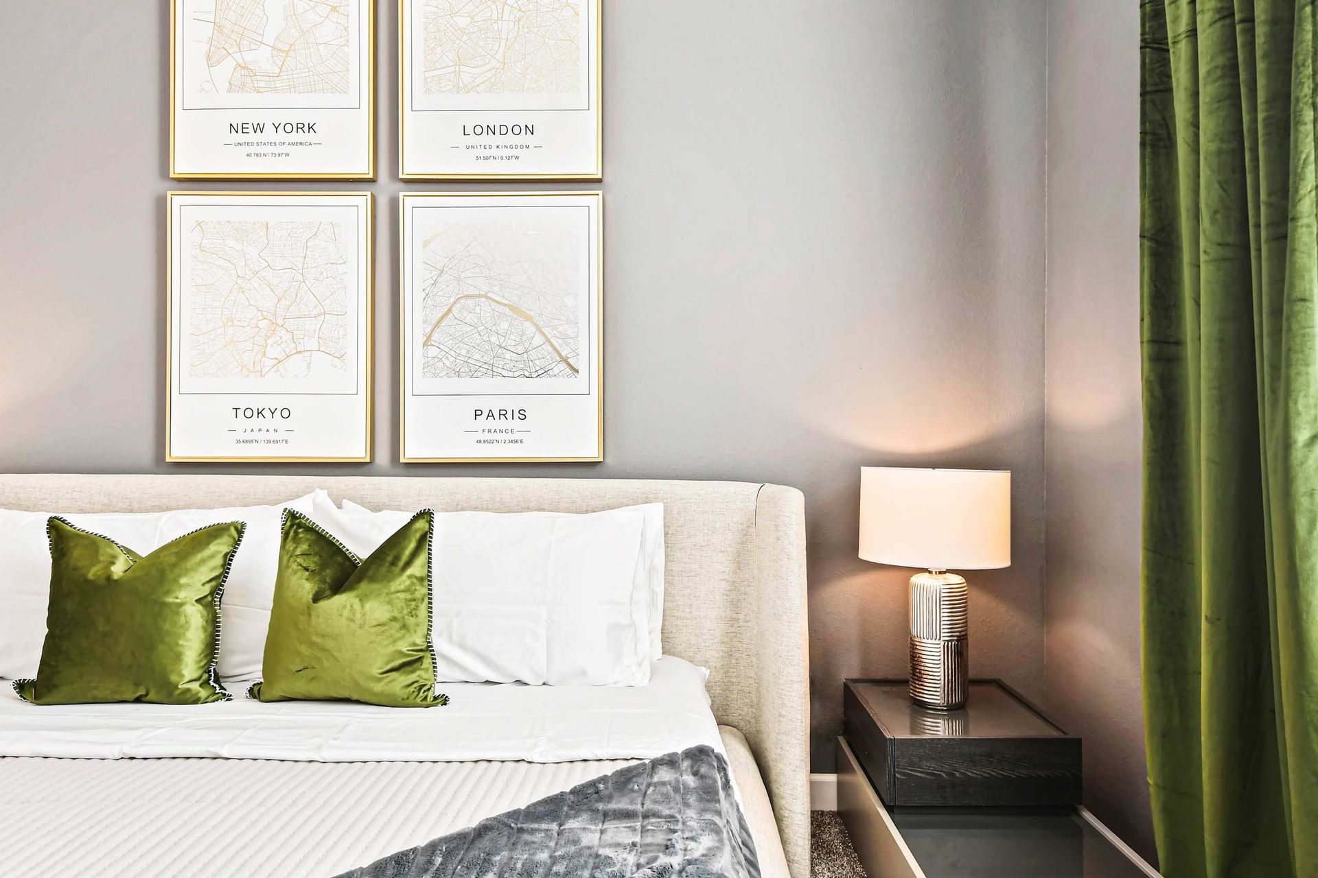 Elegant bedroom with a plush bed, stylish decor, and chic travel-inspired artwork.