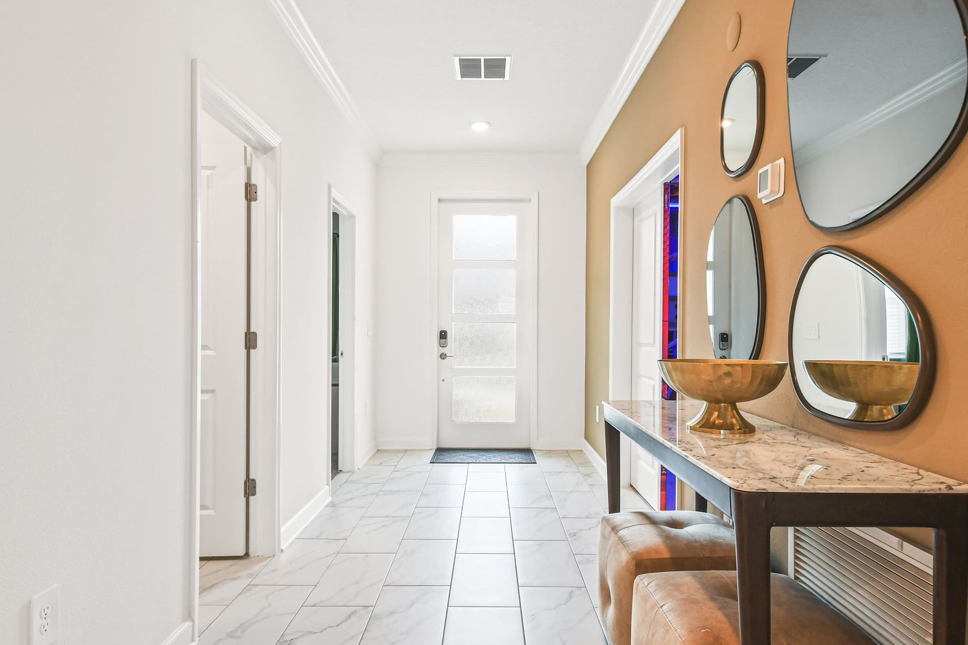 Stylish entryway with modern decor, marble accents, and elegant mirror details.