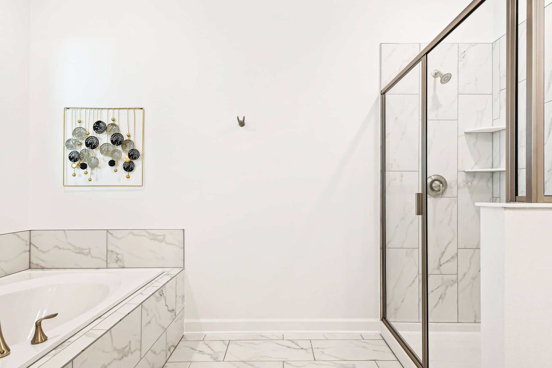 Luxurious bathroom with marble finishes, a soaking tub, and a spacious glass shower.