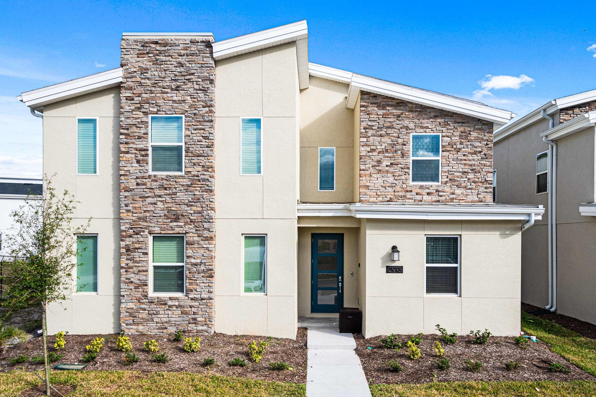 Modern luxury home with stylish stone accents, bright interiors, and a private entrance.