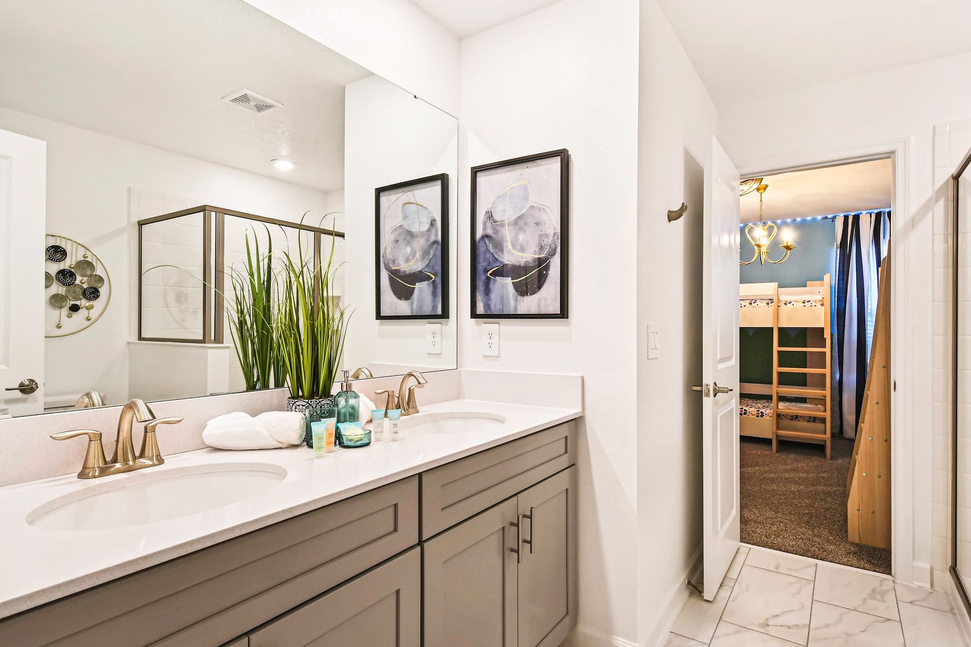 Modern bathroom with a double vanity, elegant decor, and direct access to the bunk room.