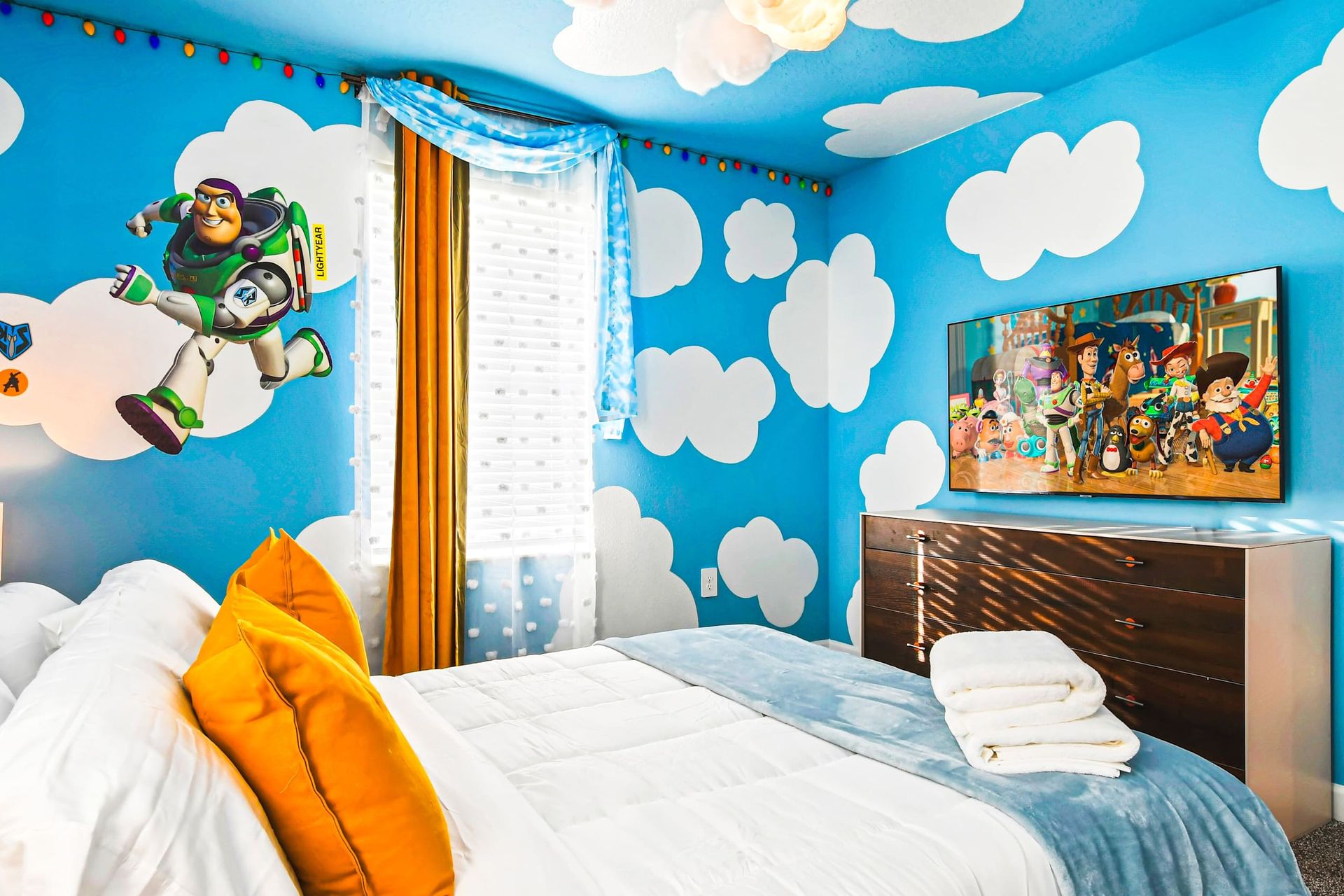 Whimsical Toy Story-themed bedroom with cloud murals, playful decor, and cozy bedding.