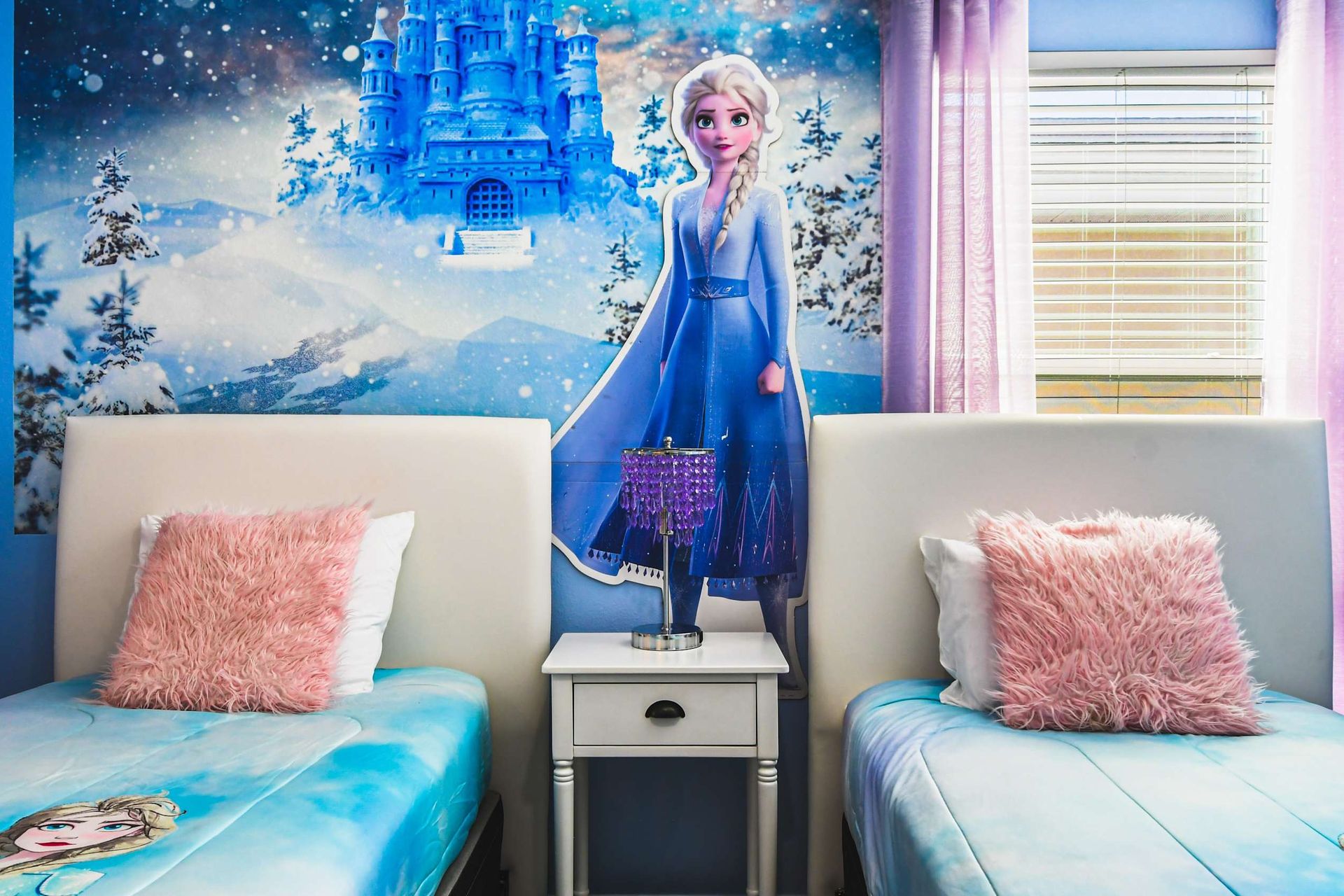 Frozen-themed kids’ room with twin beds, snowy mural, fluffy pillows and magical vibe
