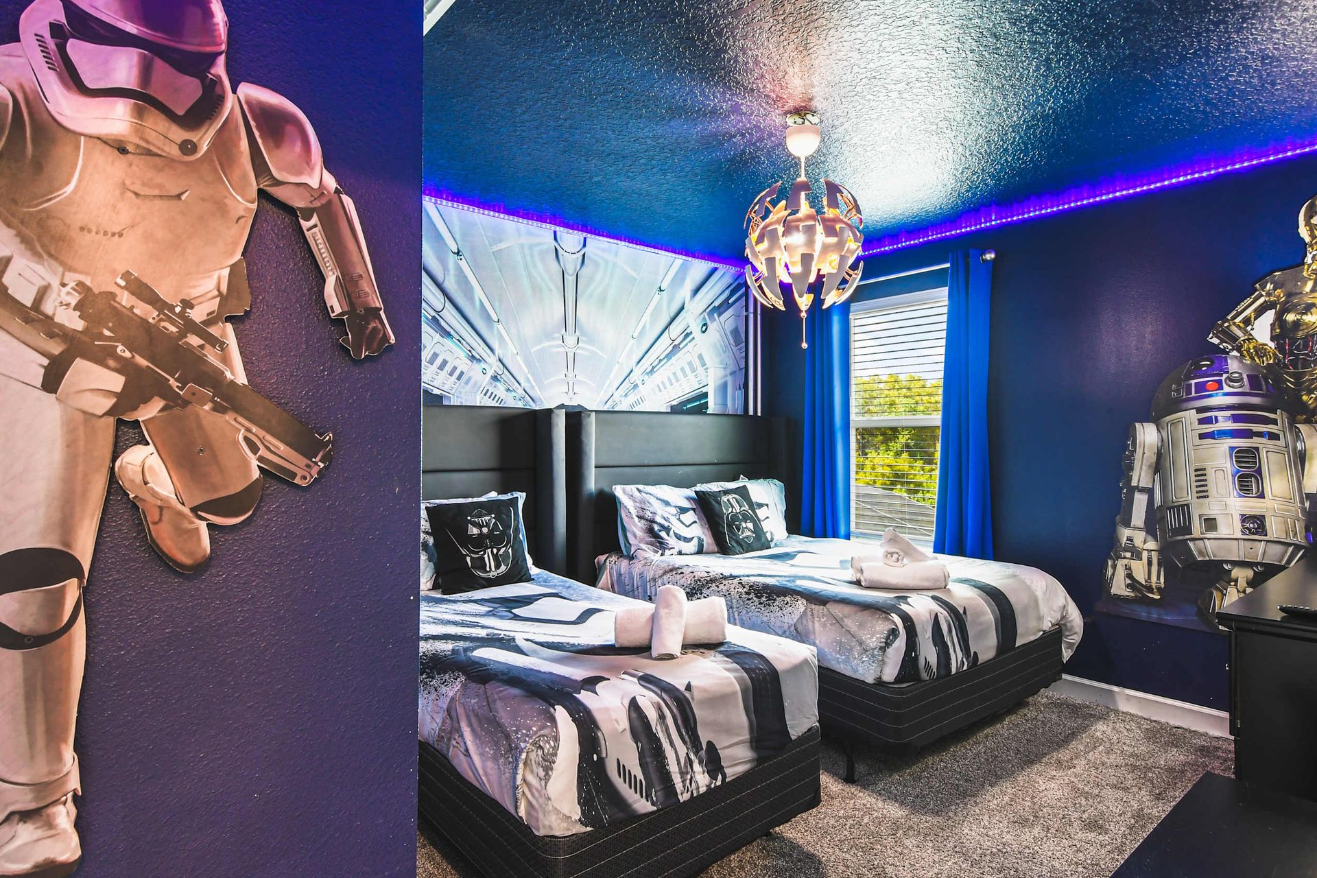 Galaxy-themed kids’ room with twin beds, fun wall art, LED lights and adventure vibe
