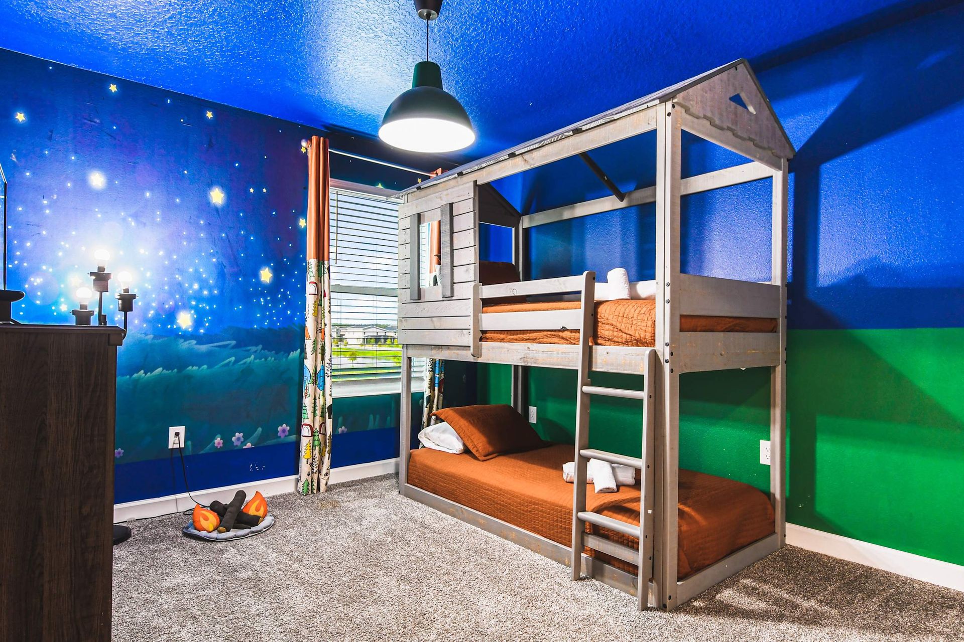 Kids’ dream room with fun bunk beds, starry mural, TV and cozy adventure vibe

