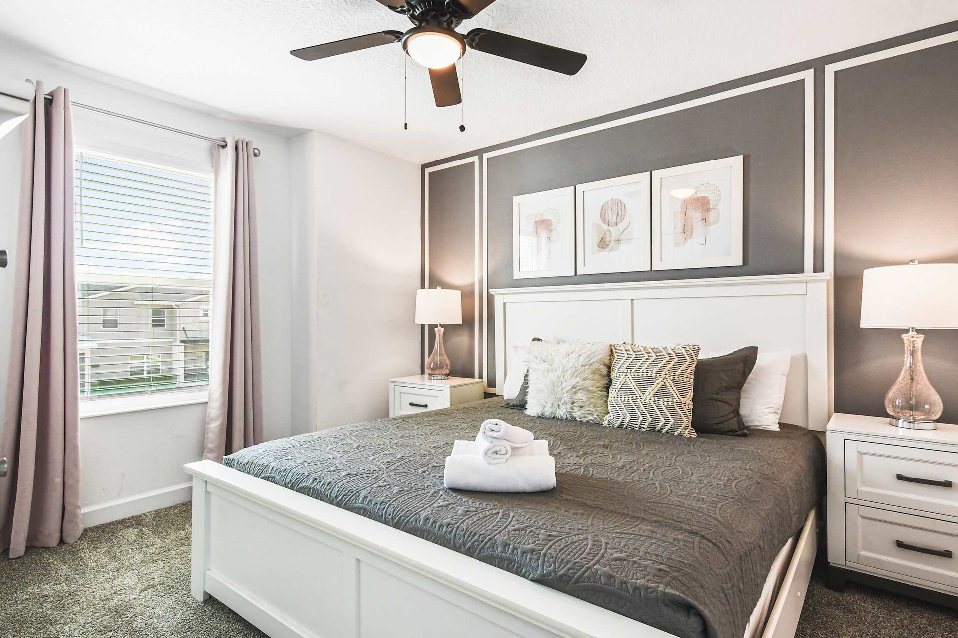 Elegant bedroom with king bed, stylish accent wall, cozy decor and natural light
