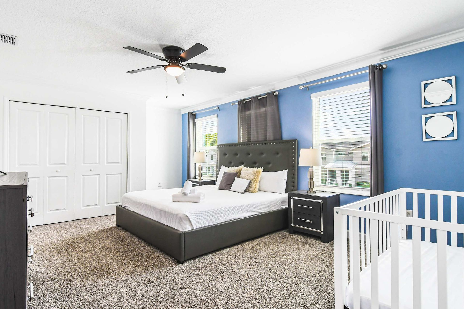 Spacious master with king bed, calming blue walls, crib, smart TV and natural light
