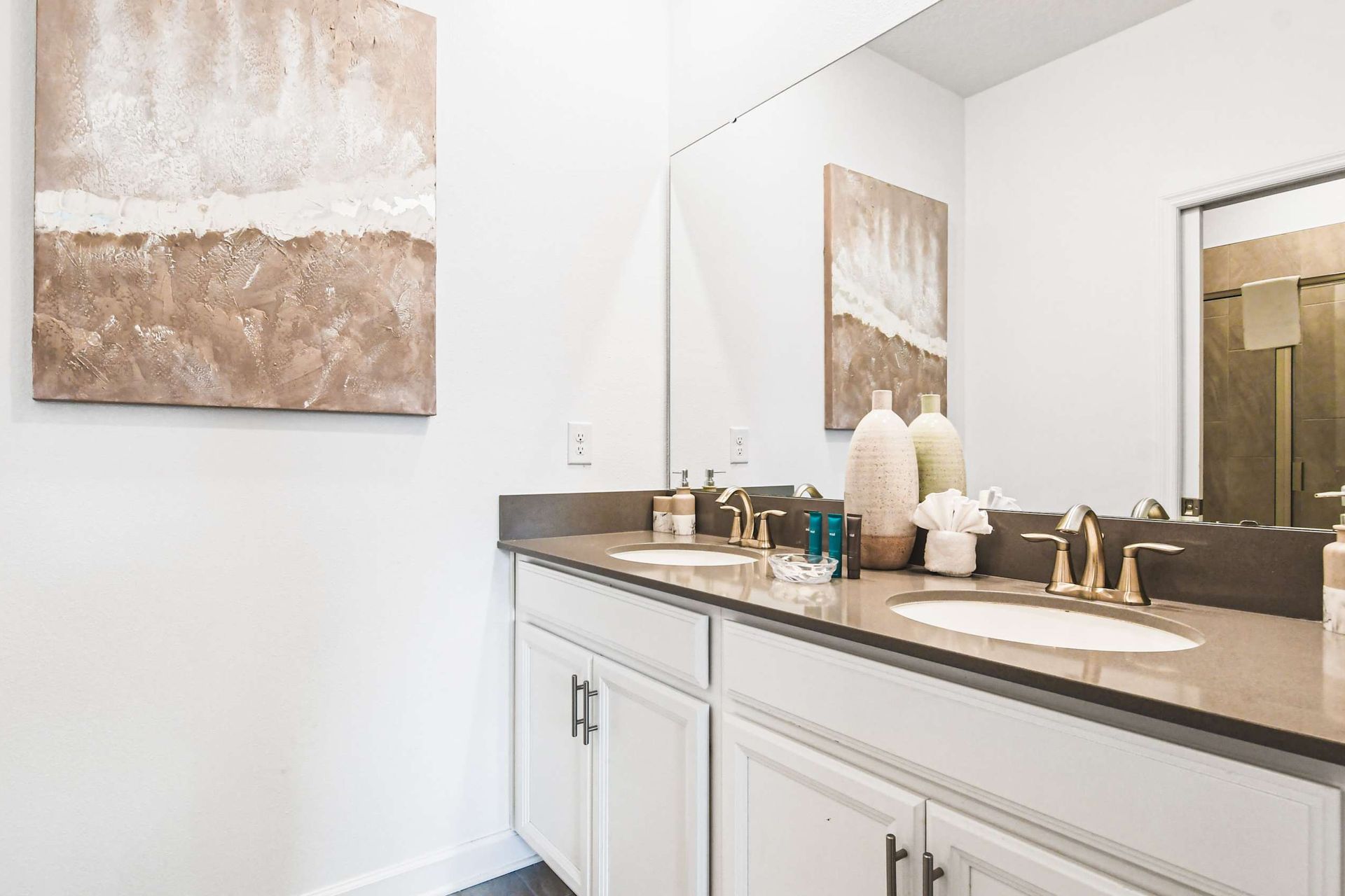 Bright modern bathroom with double sinks, sleek counters, stylish decor and big mirror
