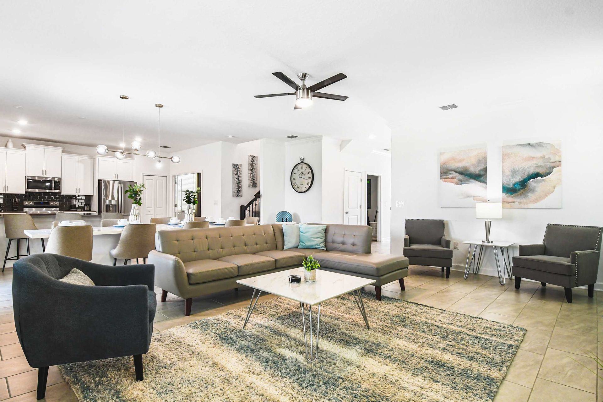 Spacious open living area with modern kitchen, comfy seating, bright and stylish
