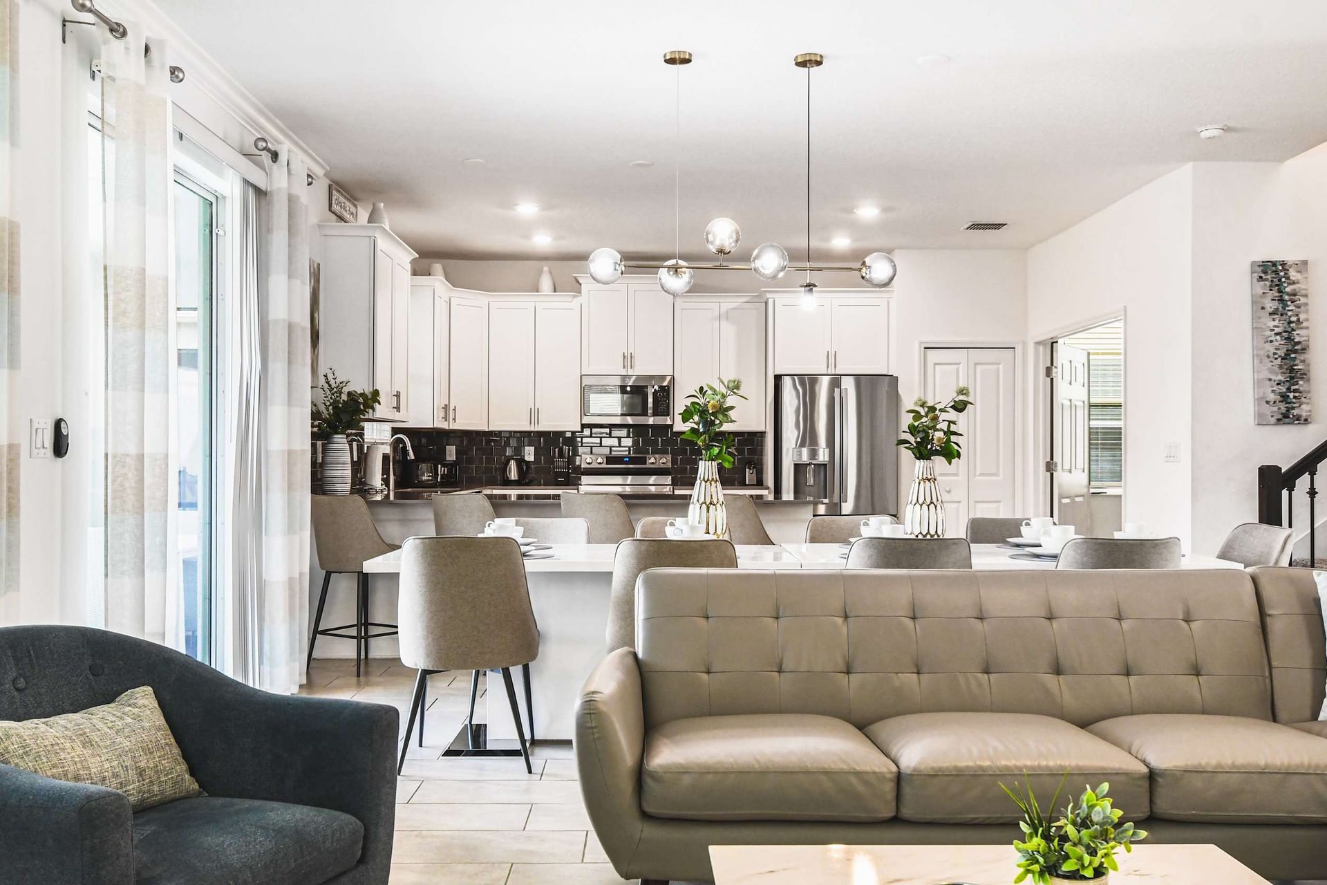 Spacious open living area with modern kitchen, comfy seating, bright and stylish
