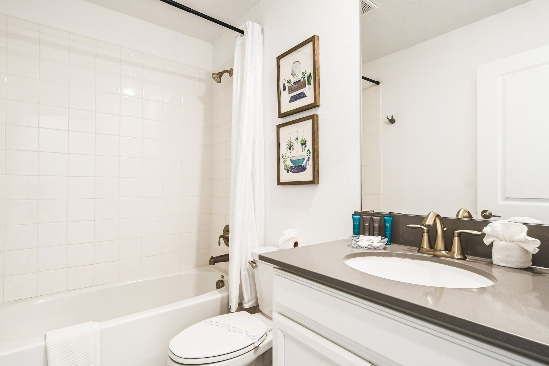 Fresh clean bathroom with tub and shower, modern vanity, big mirror and soft decor
