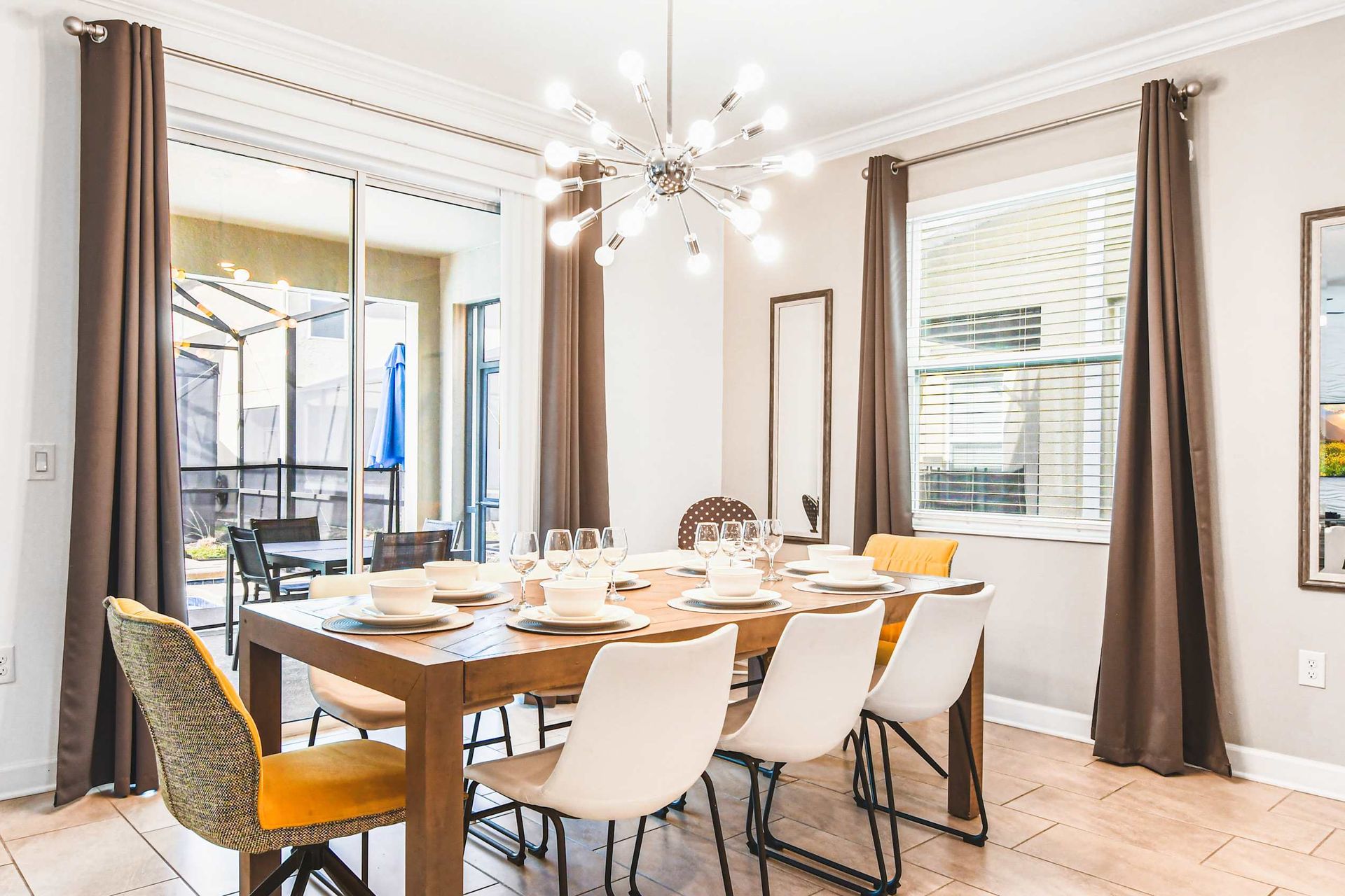 Stylish dining area with modern lighting, seating for eight, and patio access