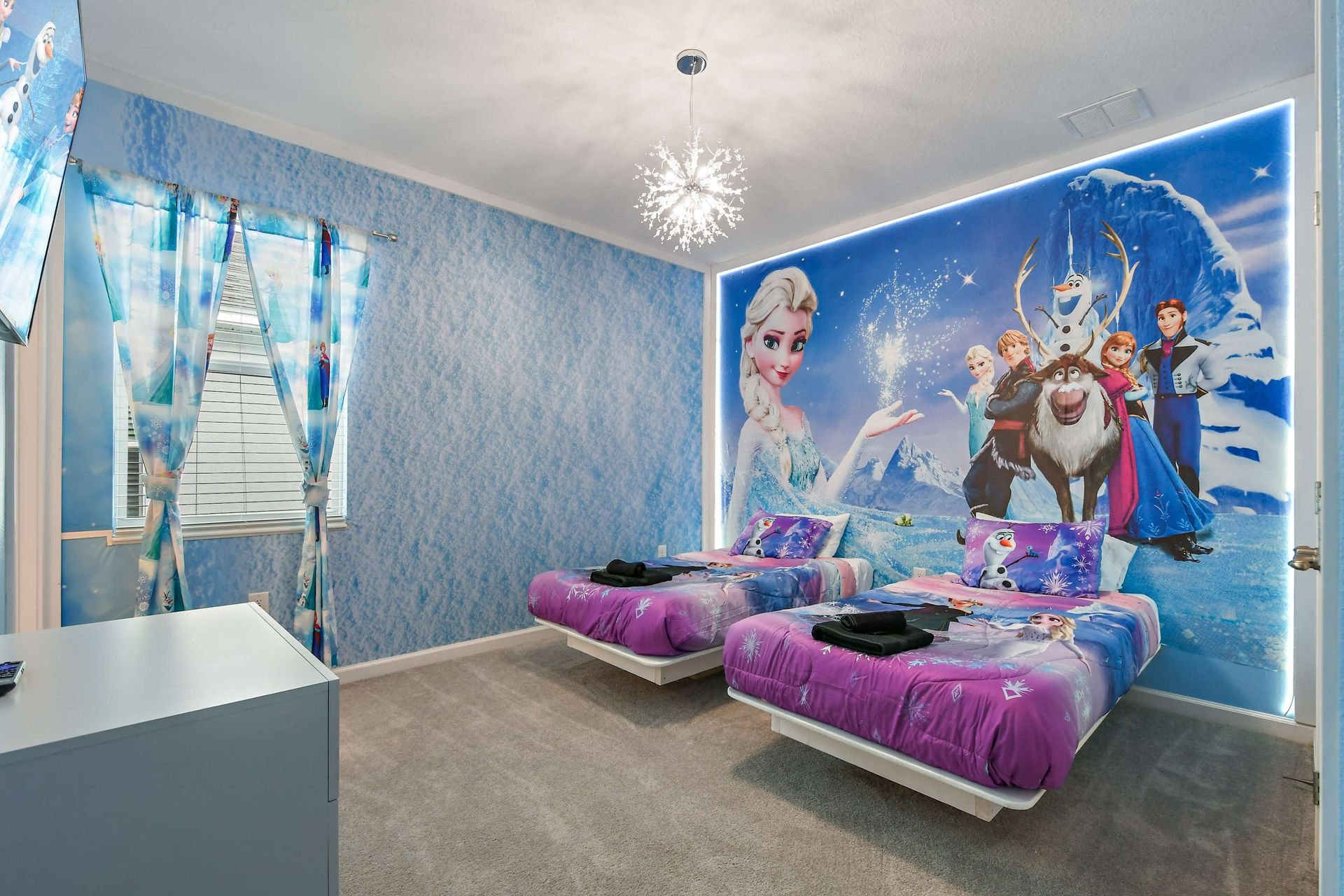 Frozen-themed bedroom with icy decor, character murals, and magical lighting.