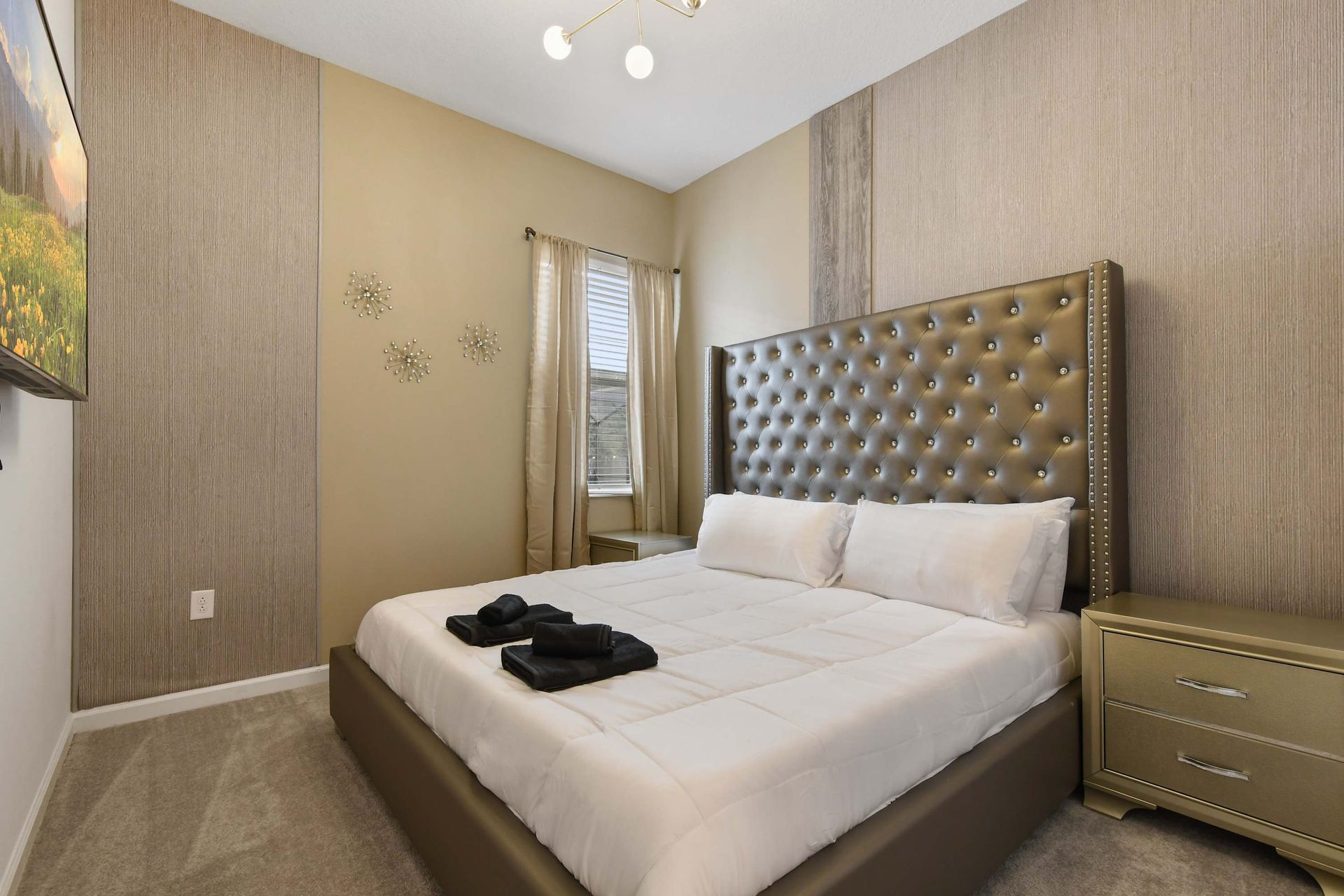 Luxurious bedroom with tufted headboard, gold accents, and elegant decor.