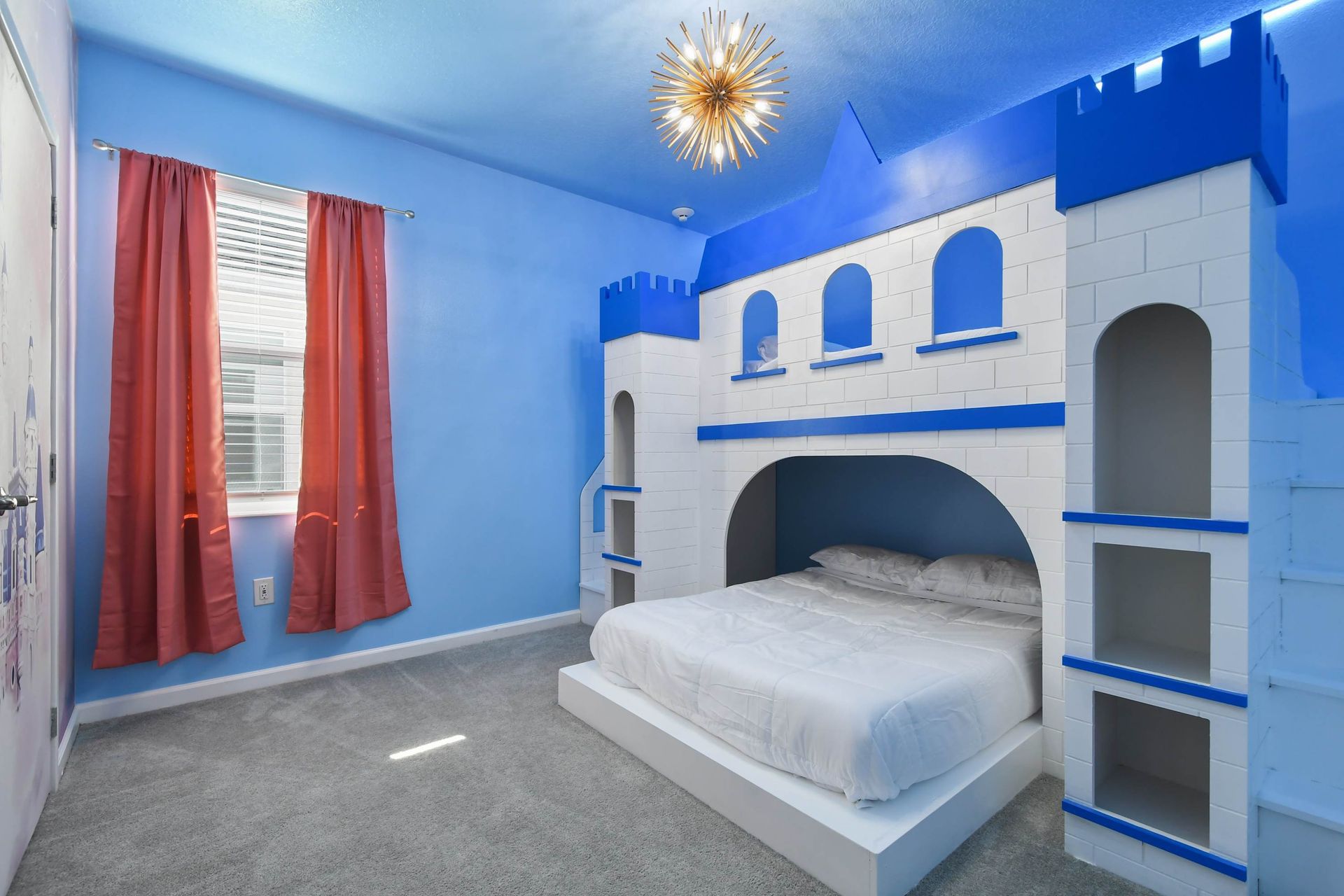 Castle-themed bedroom with bold blue accents, turret beds, and starburst lighting.