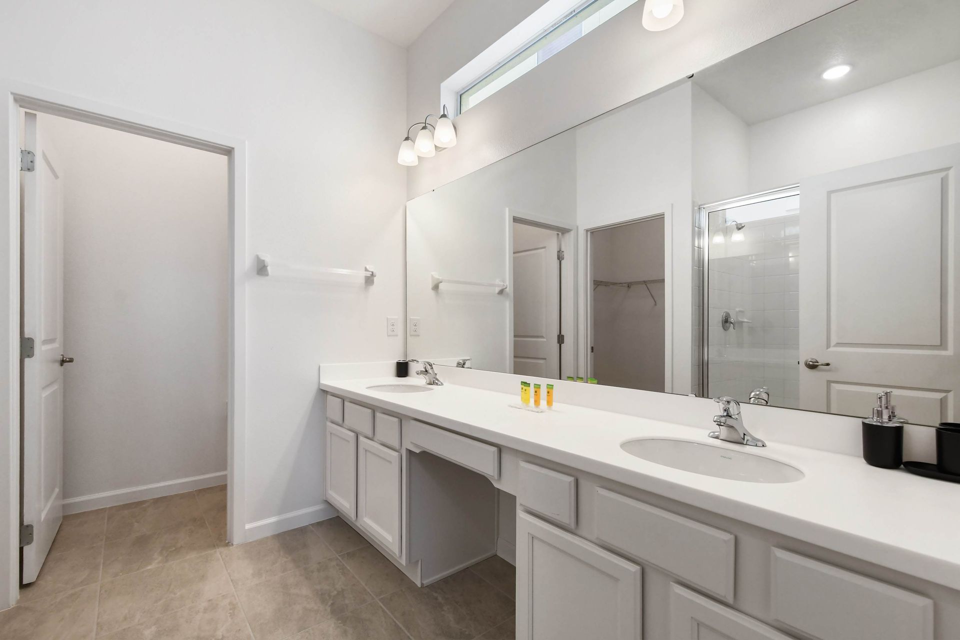 Spacious bathroom with double vanity, bright lighting, and modern fixtures.