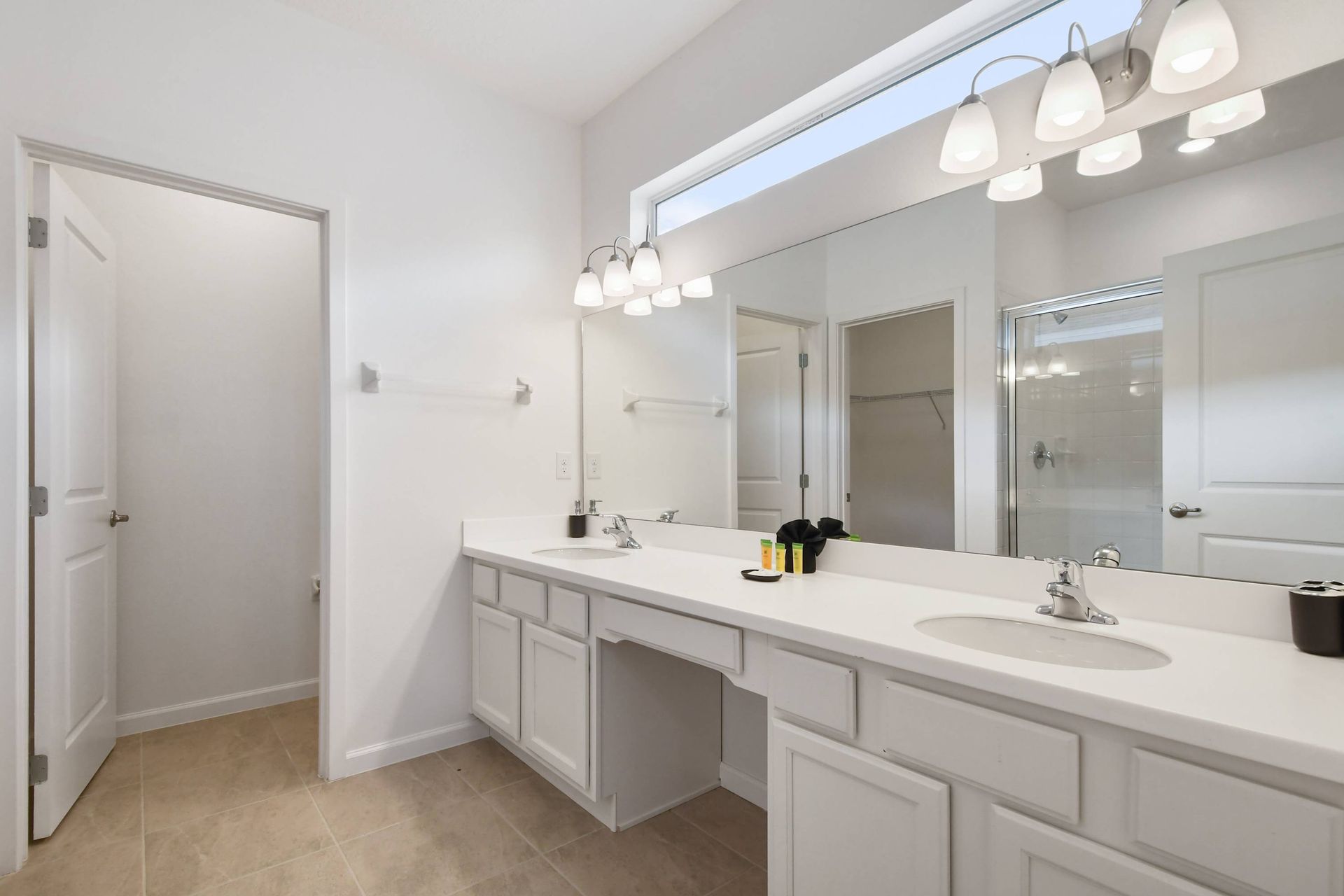 Spacious bathroom with double vanity, bright lighting, and modern fixtures.
