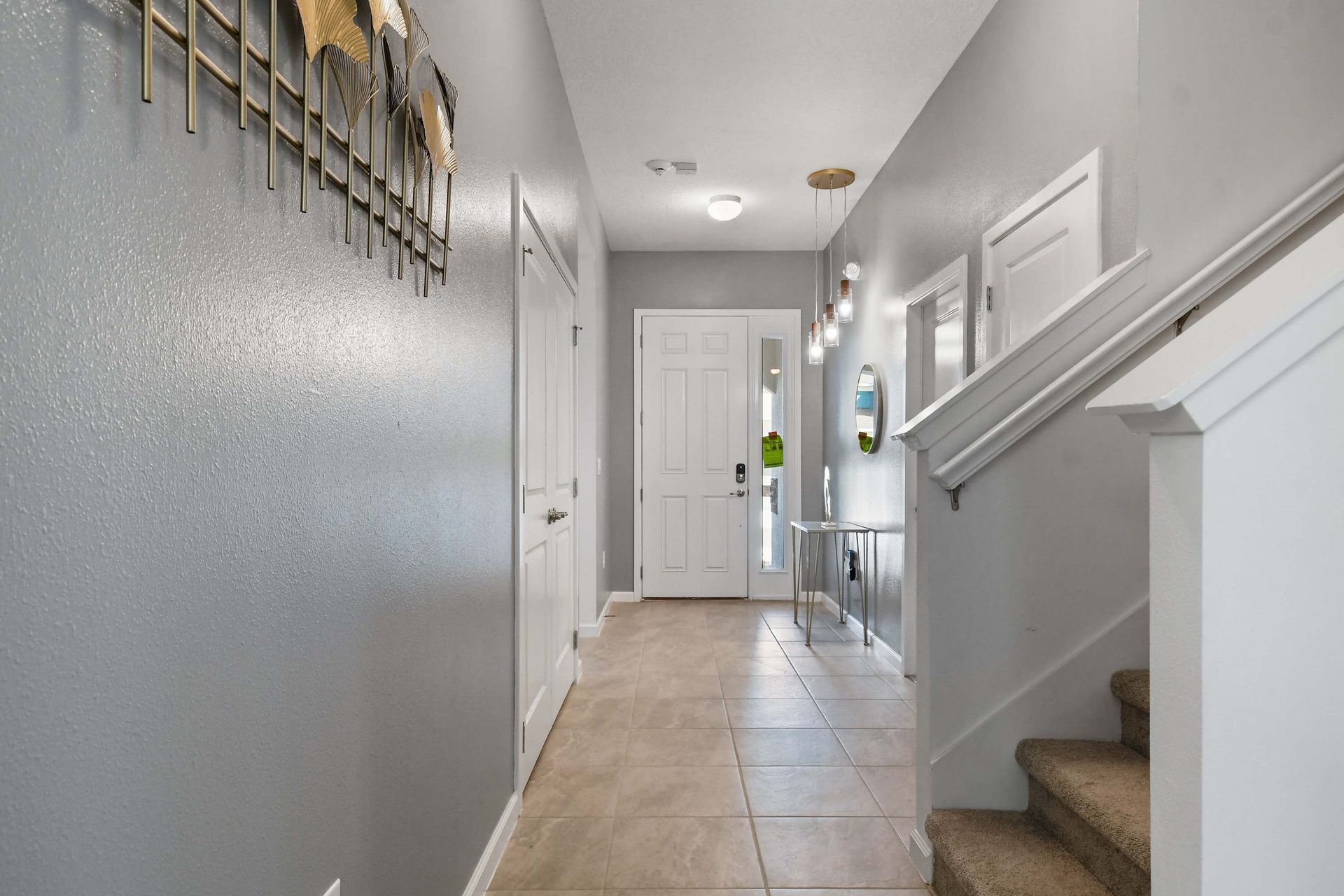 Inviting entryway with modern lighting, sleek decor, and a bright, open layout
