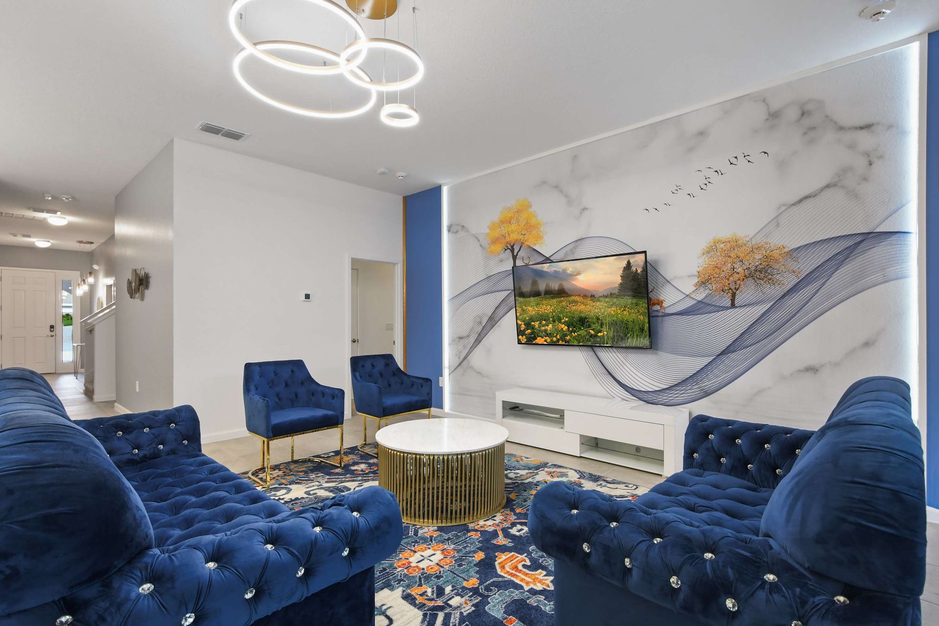 Luxurious living room with velvet seating, artful accent wall, and modern lighting.