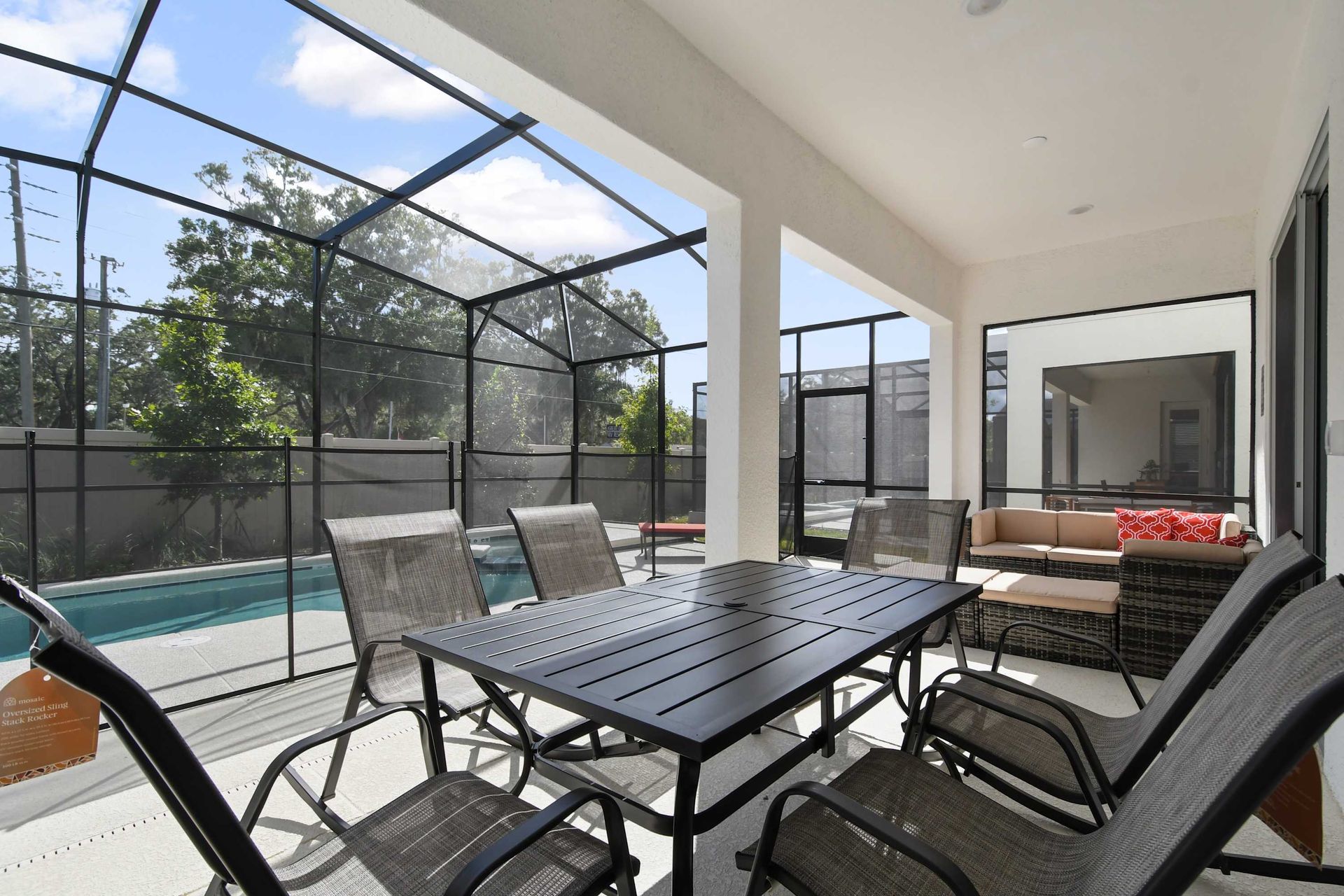 Relax on the covered patio with cozy seating and a dining area by the pool.