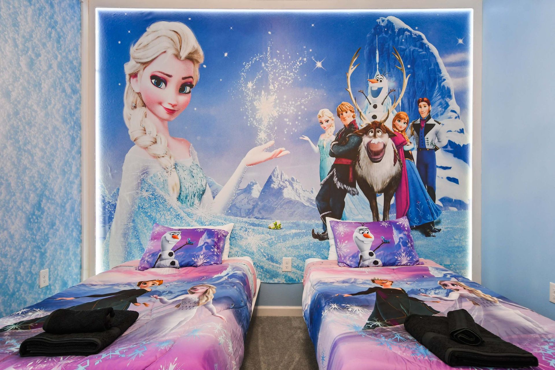 Frozen-themed bedroom with icy decor, character murals, and magical lighting.