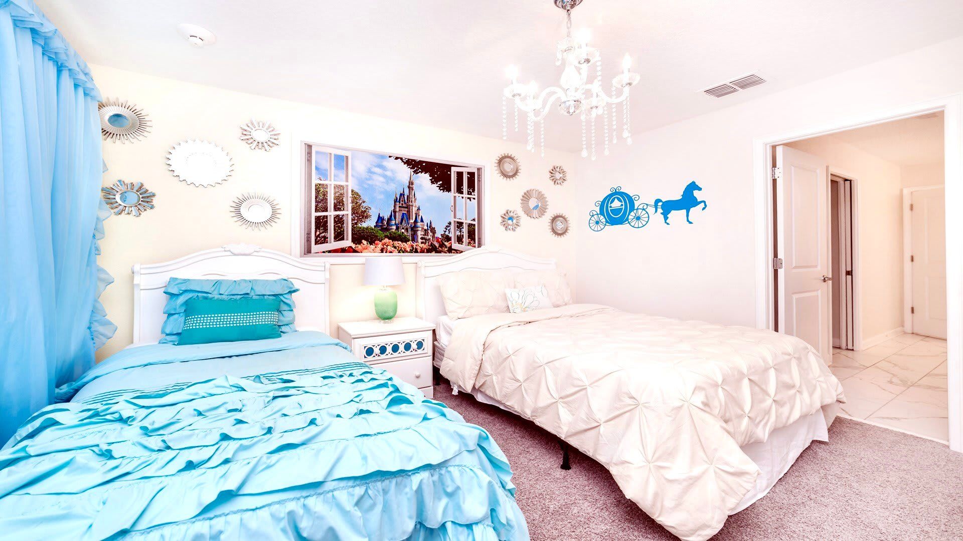 Whimsical princess-themed bedroom with chandelier, castle mural, and twin beds