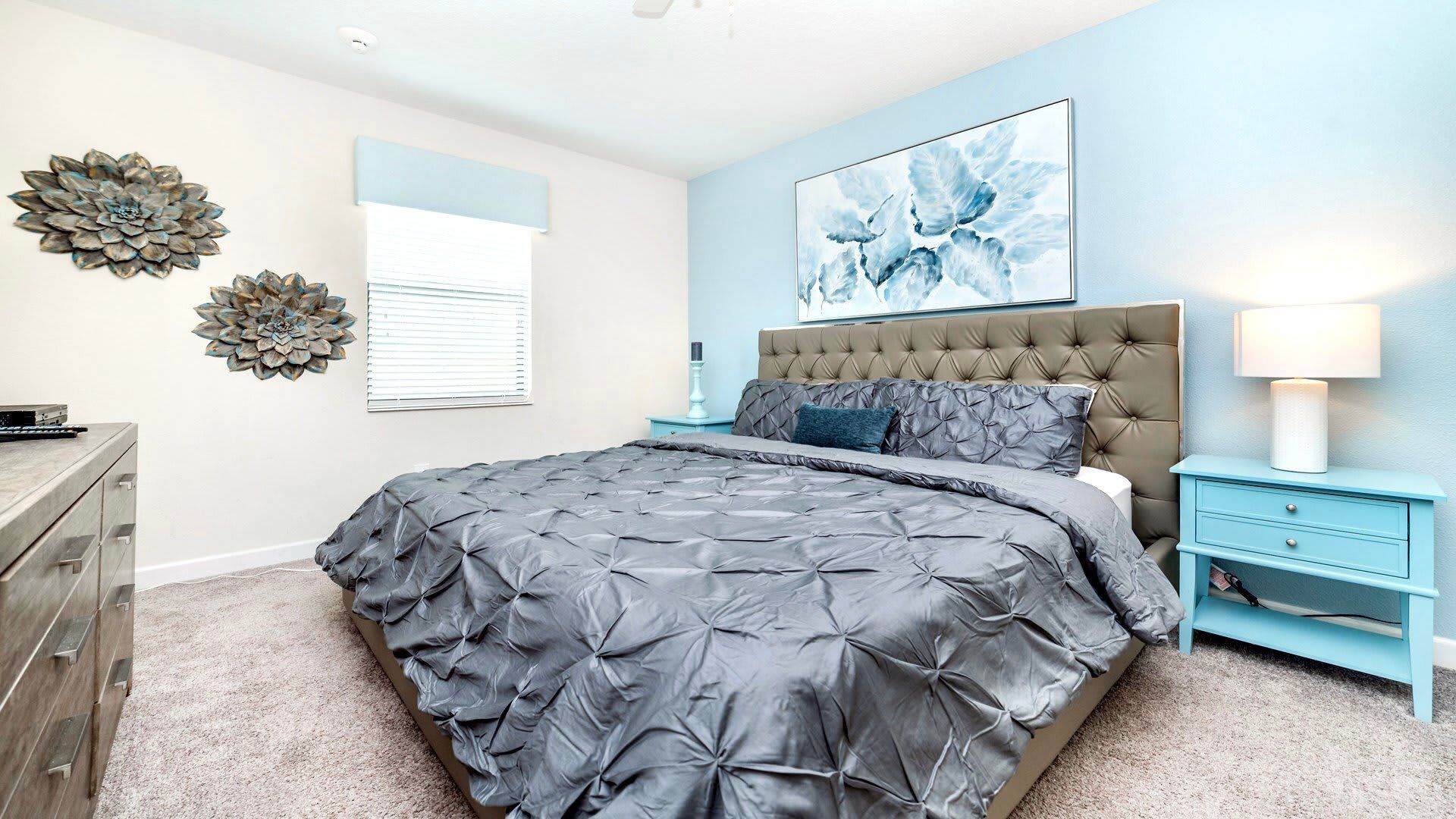 Tranquil bedroom with king bed, tufted headboard, and calming blue accents