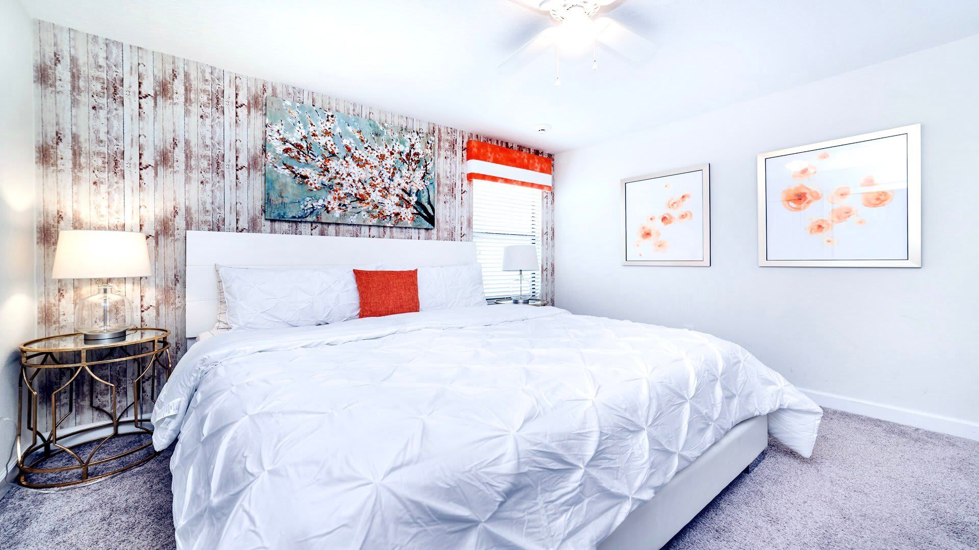 Charming bedroom with rustic accent wall, plush king bed, and soft floral decor