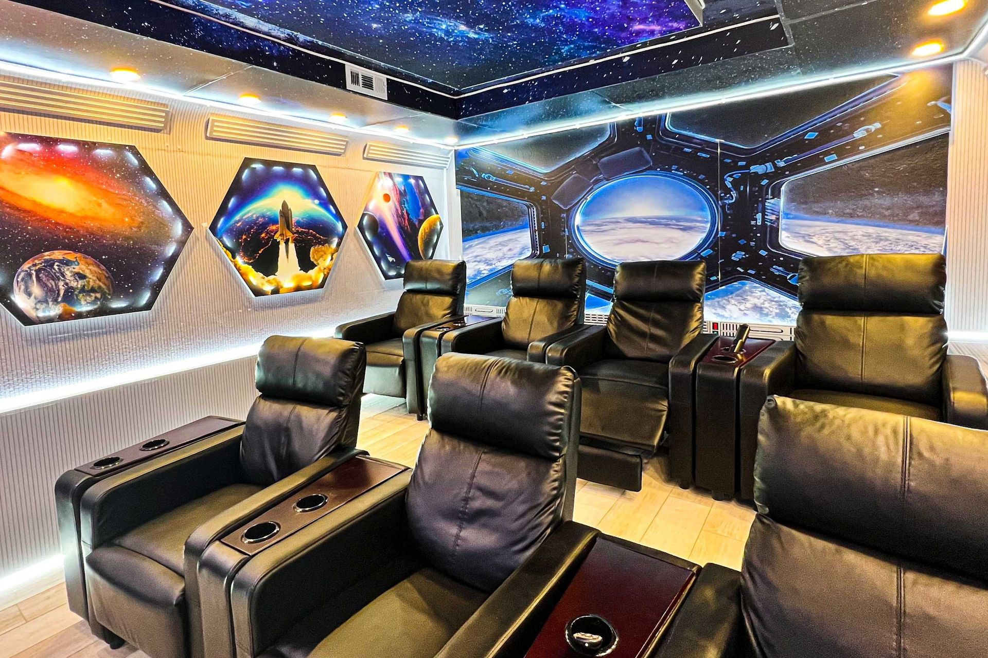 Futuristic space-themed theater room with luxury recliners and LED lighting