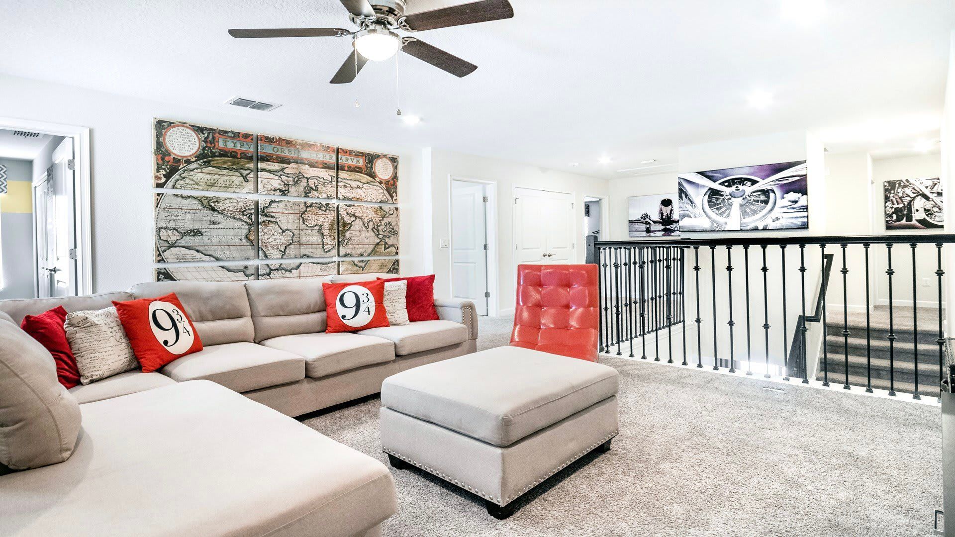 Upstairs lounge with comfy sectional, vintage travel decor, and movie-themed accents