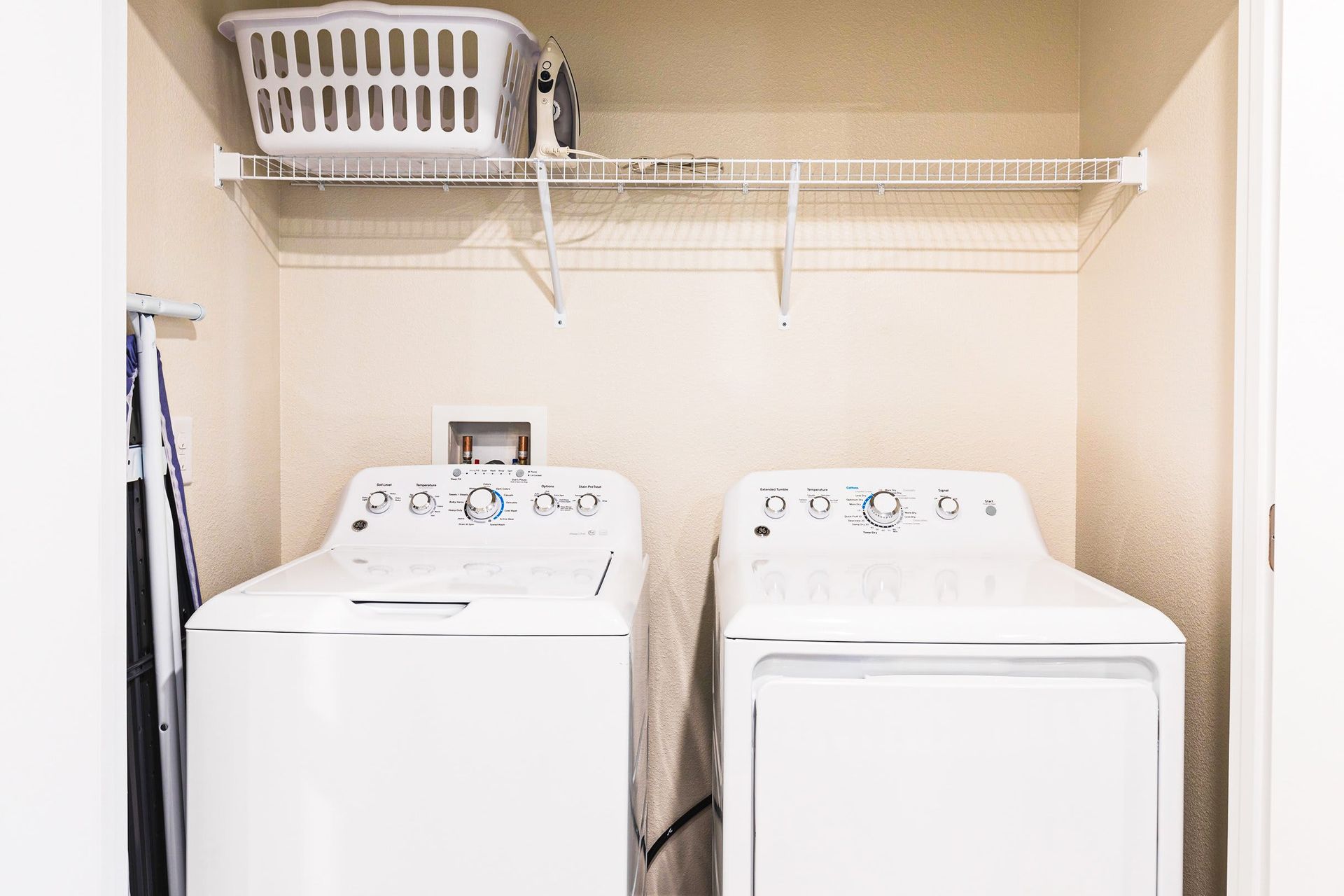 Convenient laundry nook with full-size washer, dryer, and overhead storage shelf