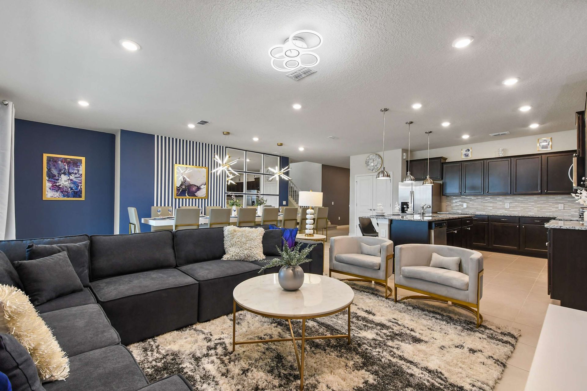Stylish living room with sleek TV wall, cozy seating, and modern gold accents