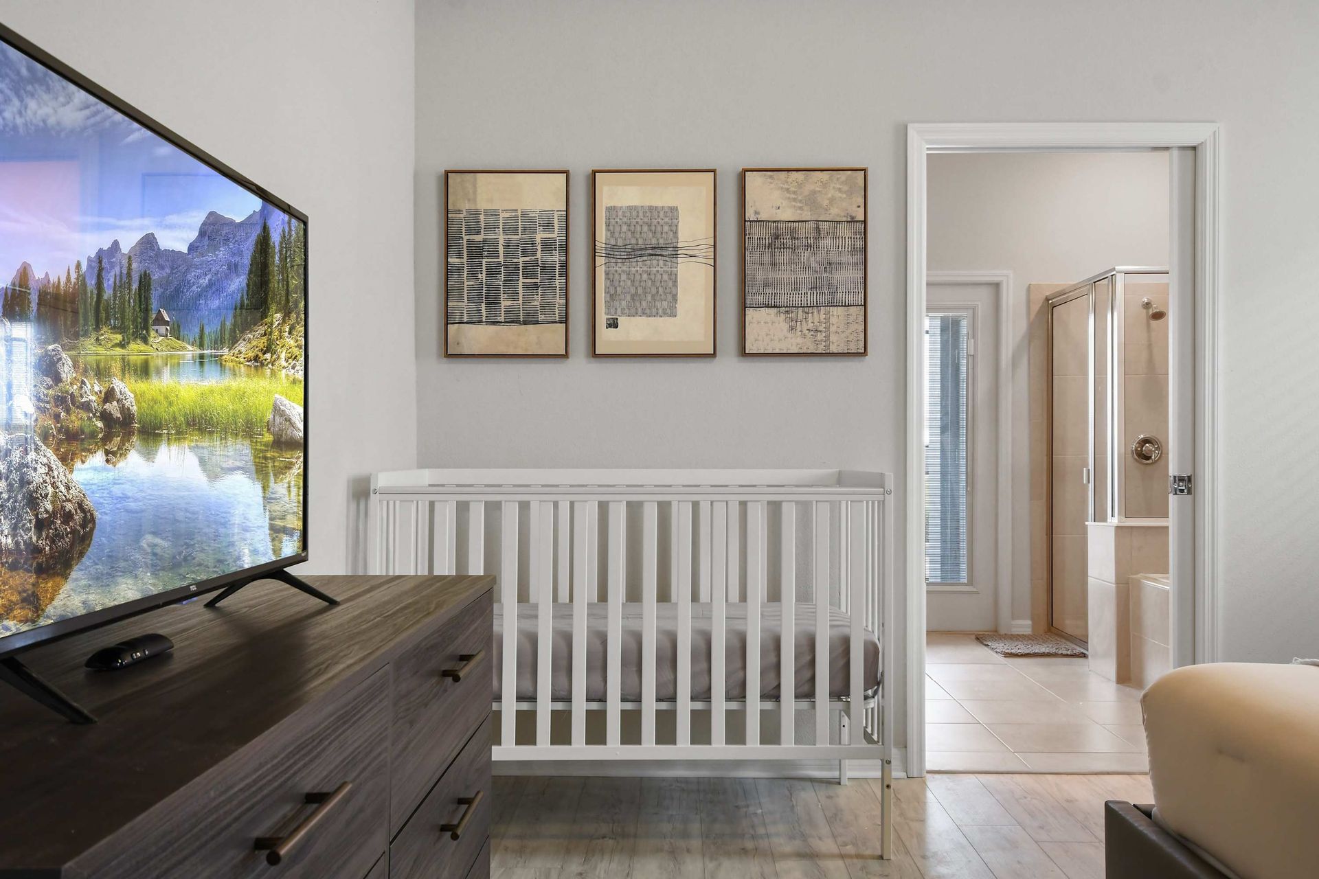 Cozy master suite with TV, crib for little ones, and private ensuite bathroom