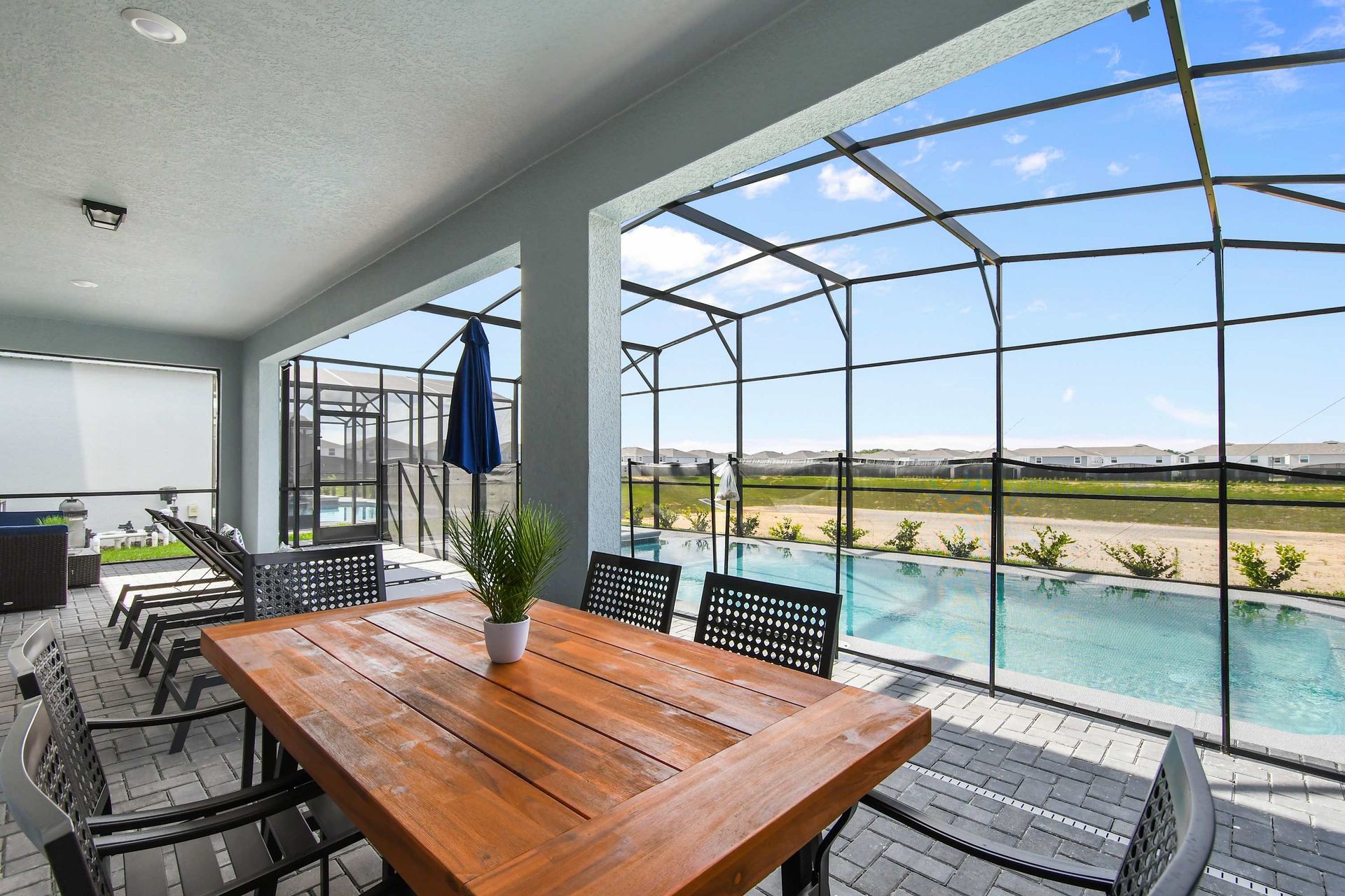 Spacious screened patio with private pool, dining area, loungers, and sunny views