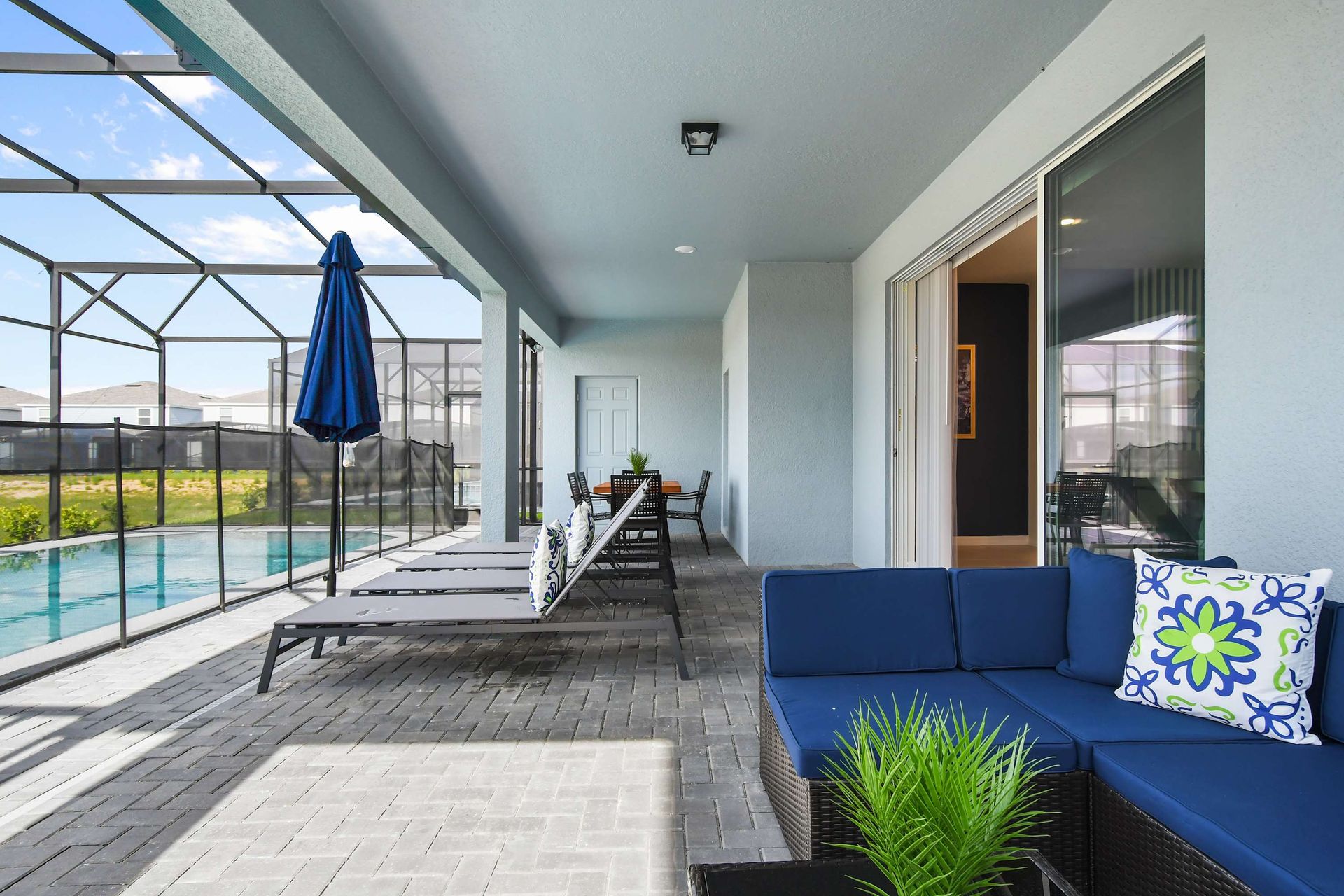 Spacious lanai with lounge chairs, outdoor sofa seating, and dining area by the pool