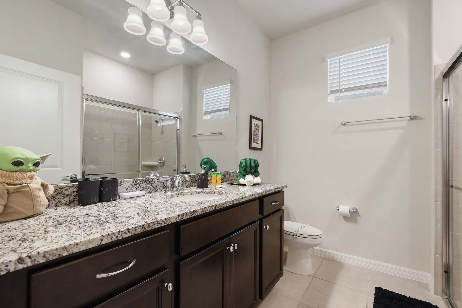 Fun family bathroom with granite vanity, walk-in shower, and playful themed touches