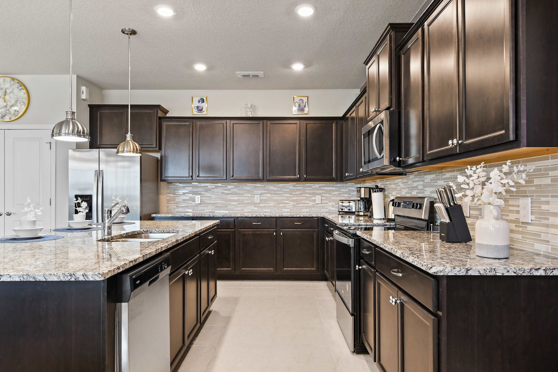 Gourmet kitchen with granite countertops, stainless steel appliances, and dark cabinetry