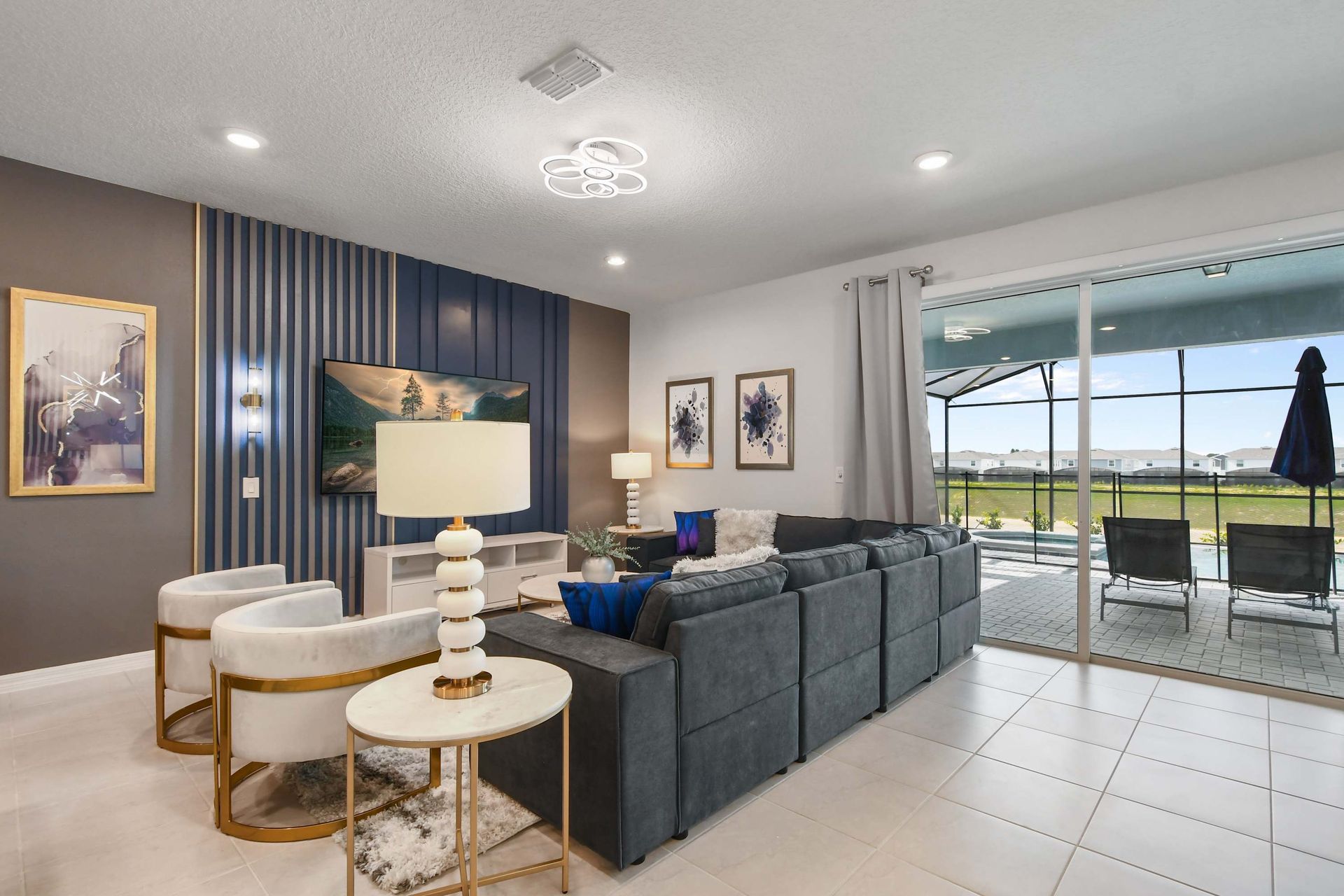 Stylish living room with sleek TV wall, cozy seating, and modern gold accents