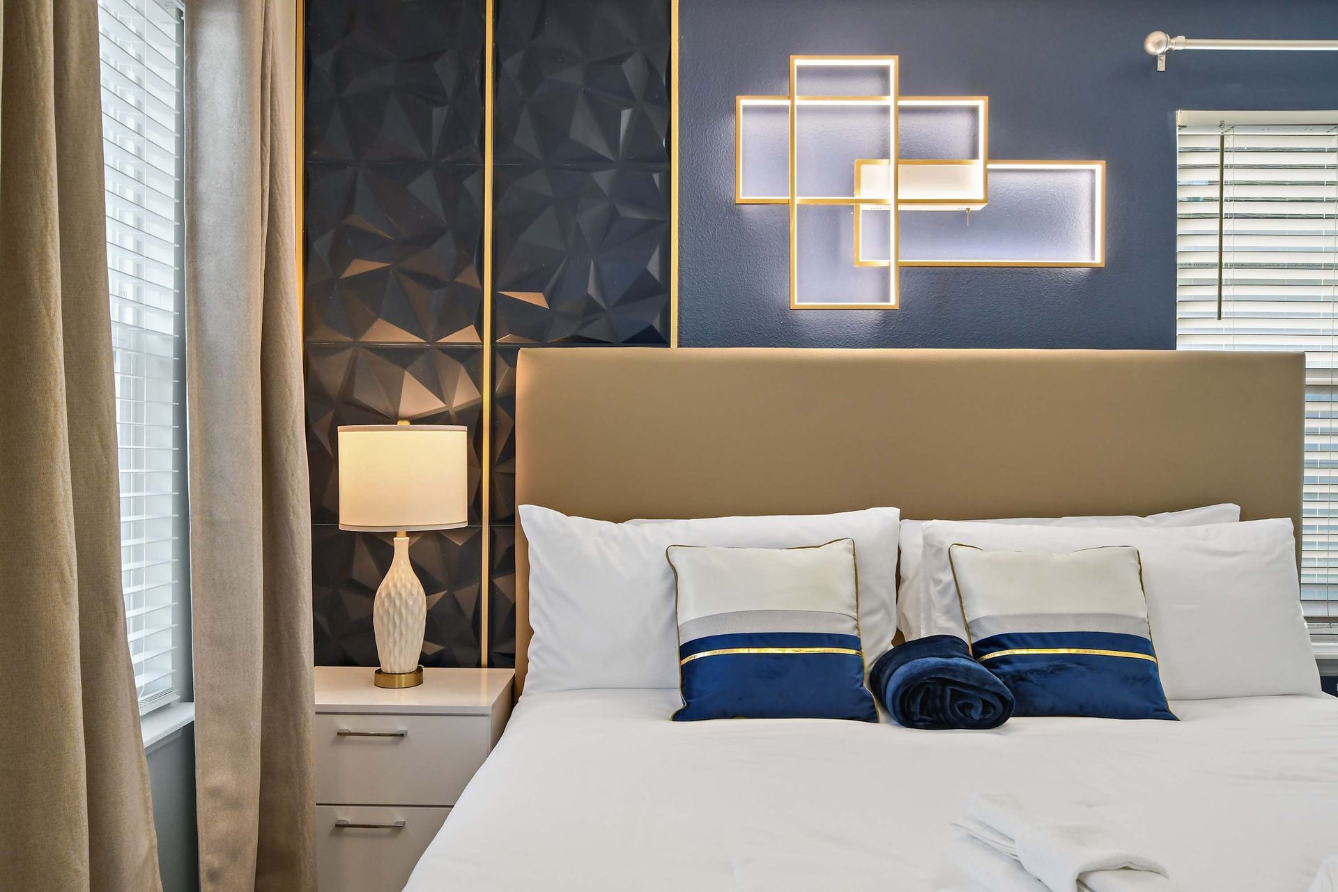 Sophisticated bedroom with king bed, ambient lighting, and elegant navy accents