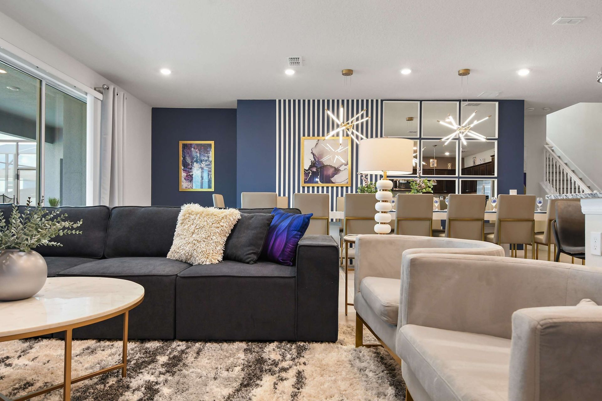 Stylish living room with sleek TV wall, cozy seating, and modern gold accents