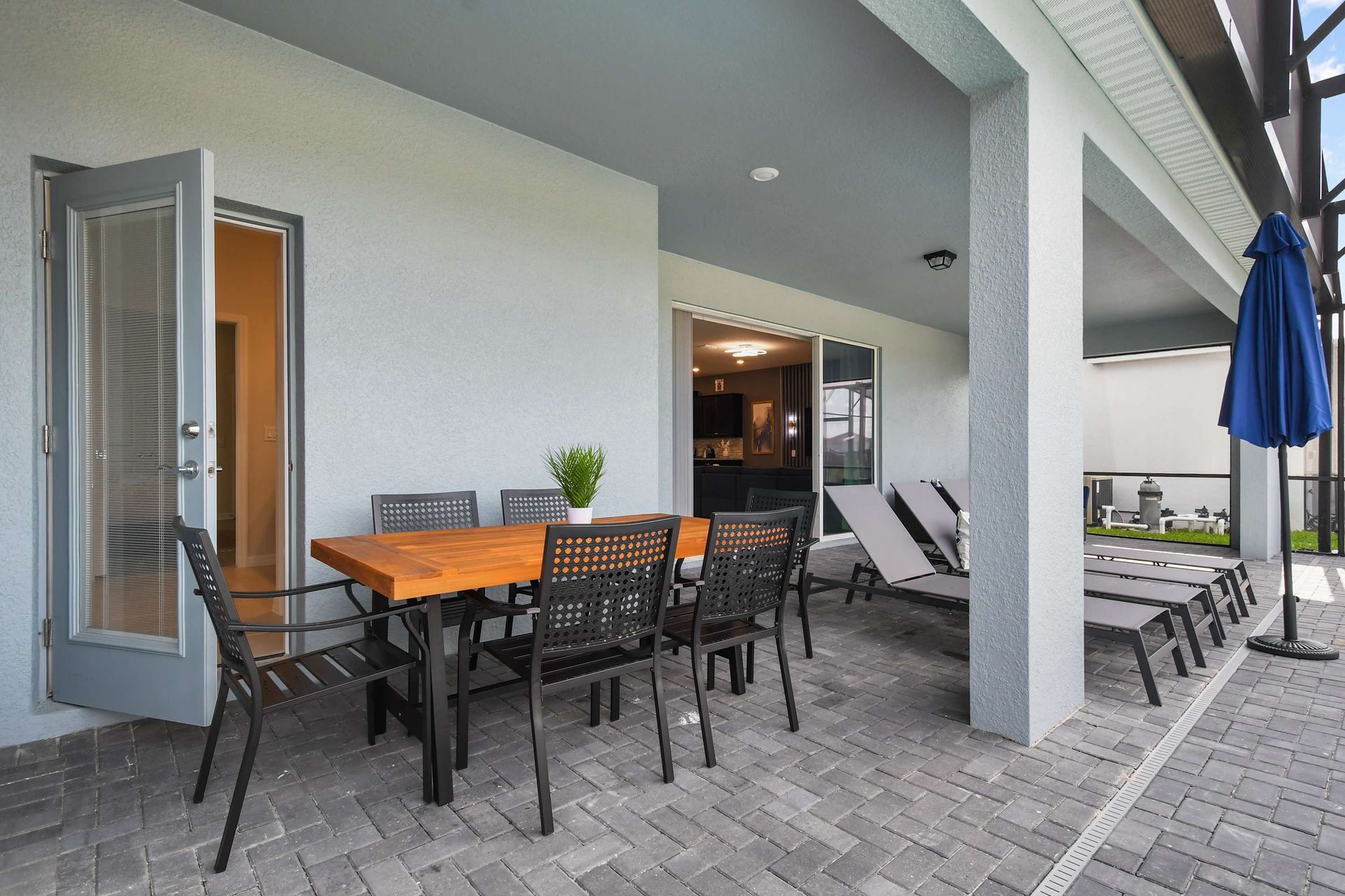 Covered patio with dining for eight, poolside loungers, and seamless indoor access